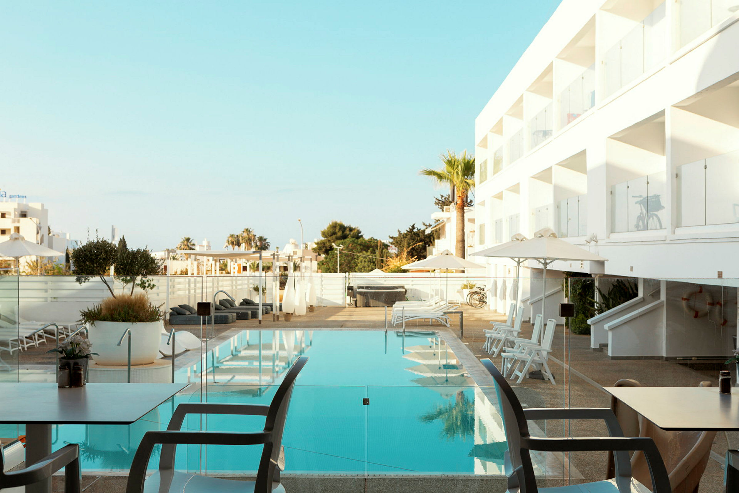 Simringspool vid hotell med solstolar och parasoller. (AI-genererad text)
