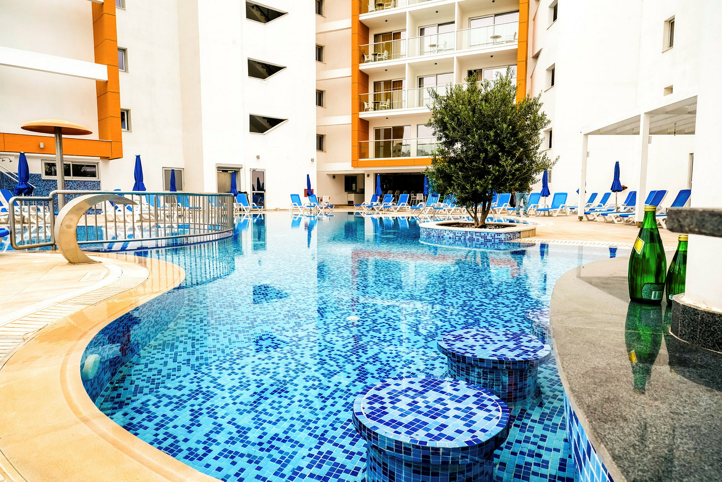 Poolområde med omgivande solstolar vid ett hotell. (AI-genererad text)