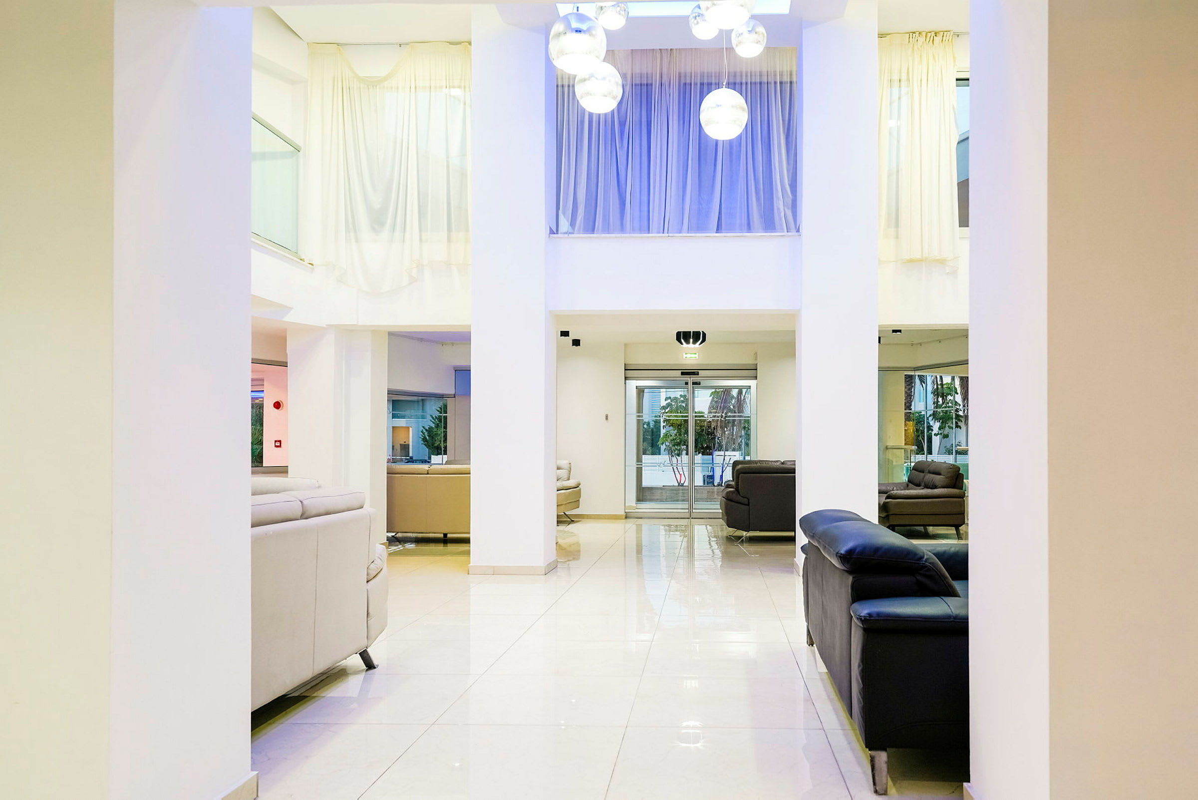 Ljus hotellobby med soffgrupper och stora fönster. (AI-genererad text)