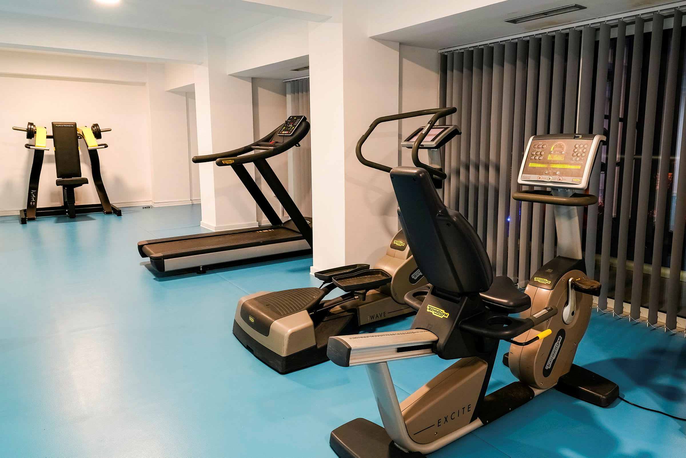Ett gym med träningsmaskiner inklusive en löpband och motionscyklar. (AI-genererad text)