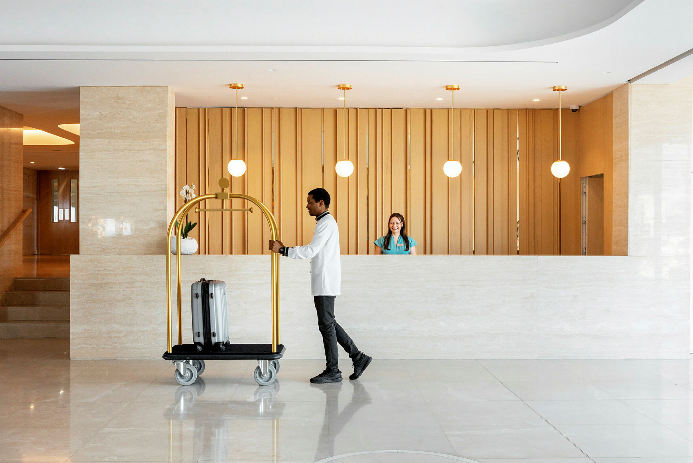 En hotellreception med en man som skjuter en bagagevagn. (AI-genererad text)