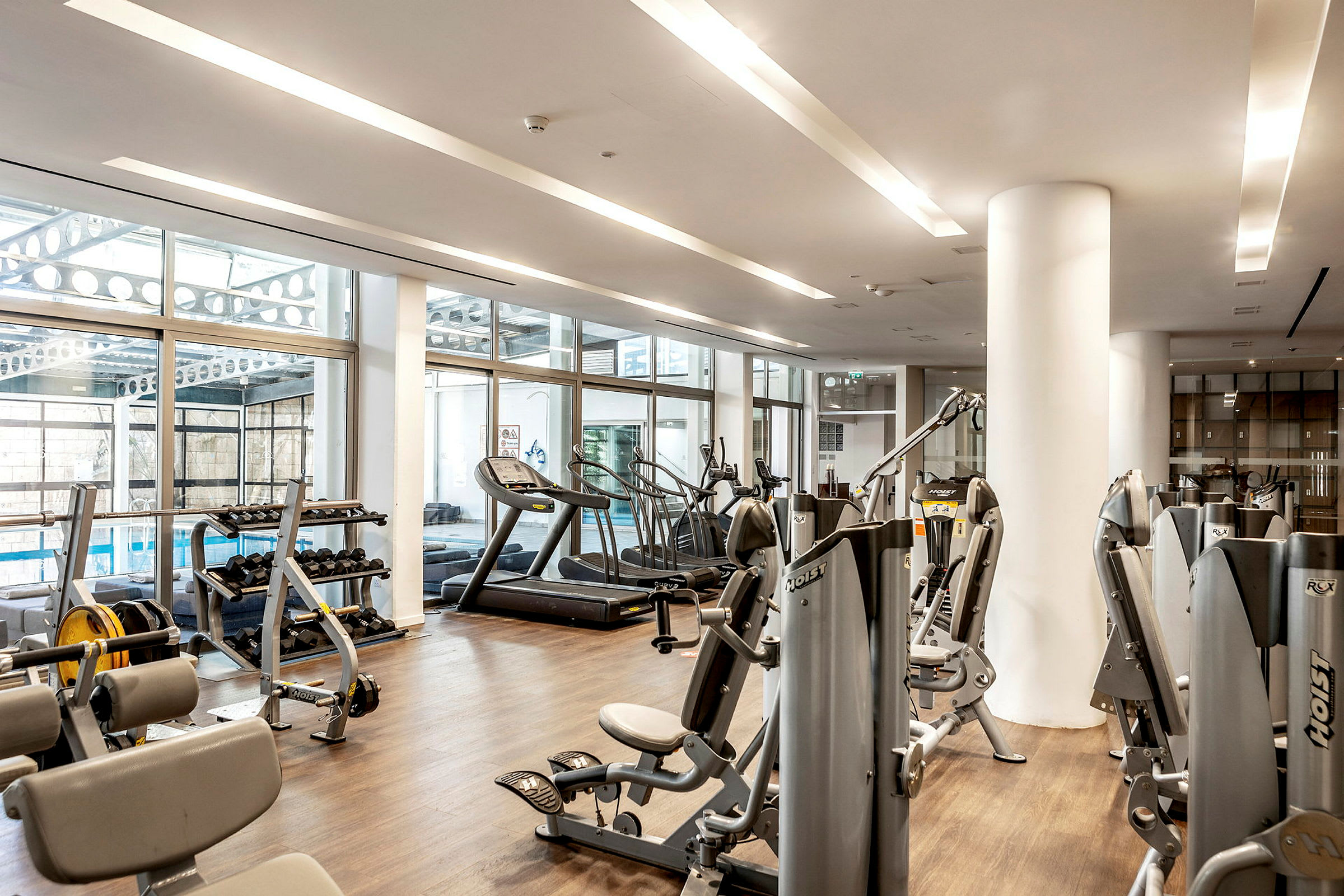 Gym med träningsutrustning och stora fönster. (AI-genererad text)