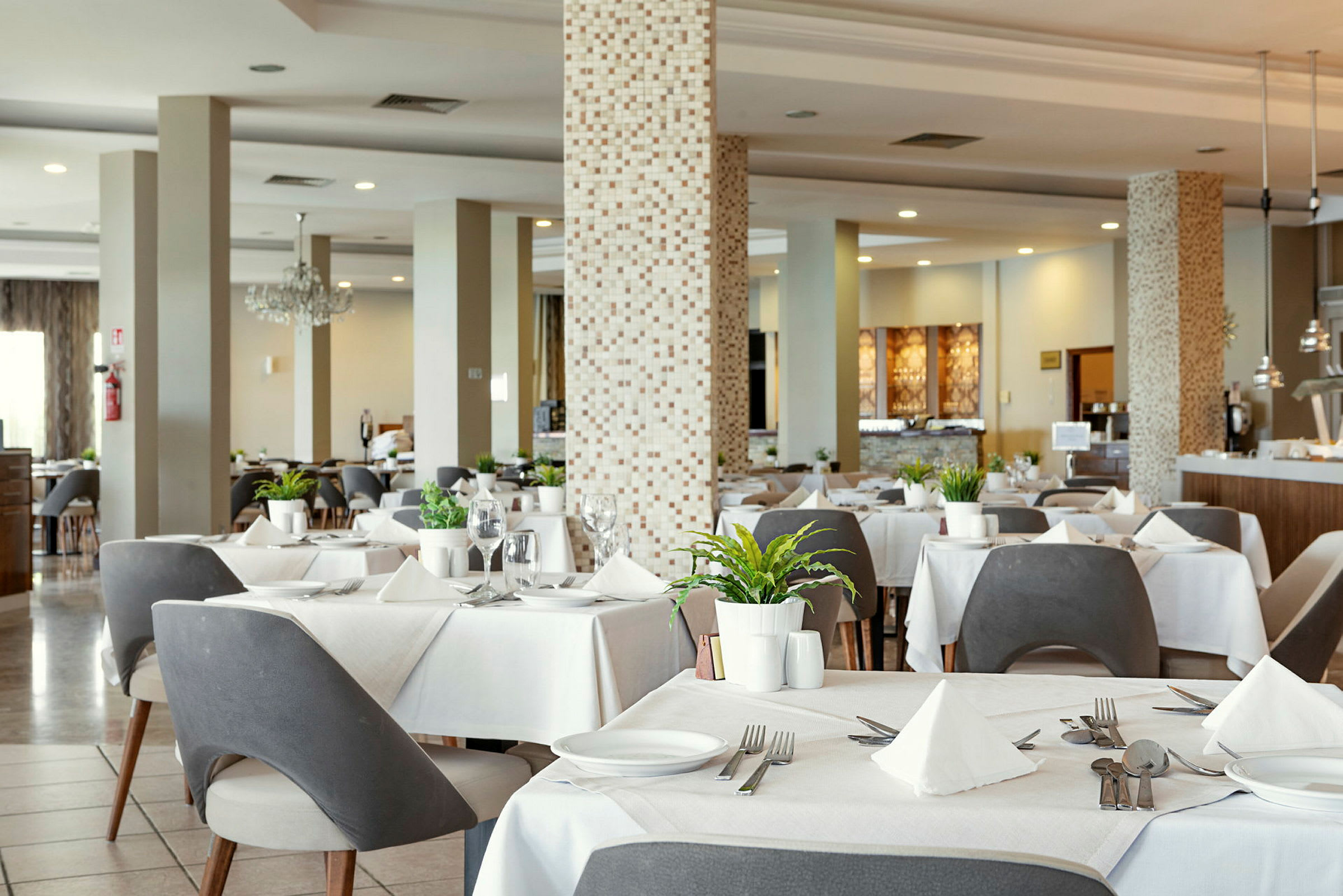 Restaurang med dukade bord, moderna stolar och dekorationer. (AI-genererad text)