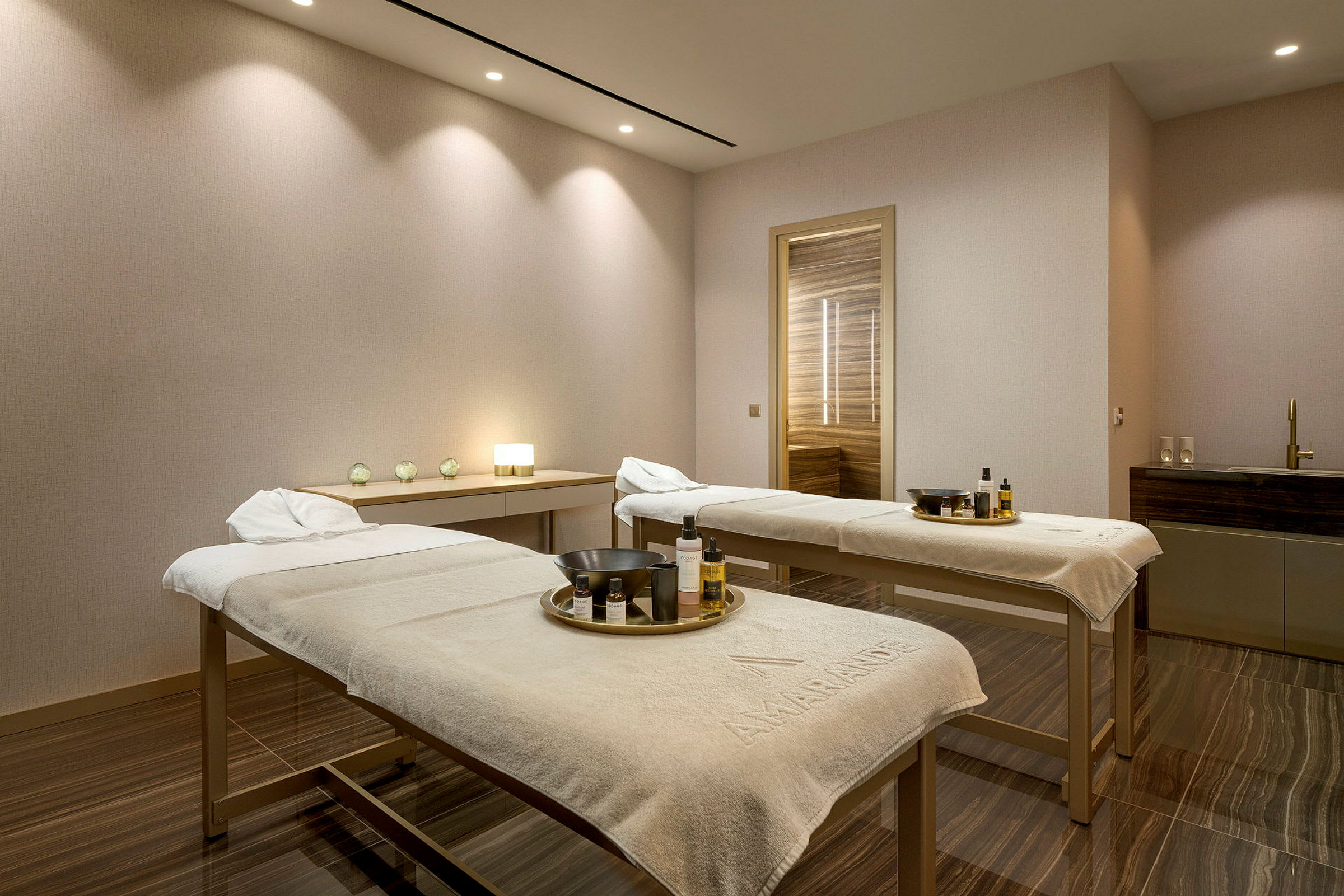 Två massagebänkar i ett spa-rum med dämpad belysning. (AI-genererad text)
