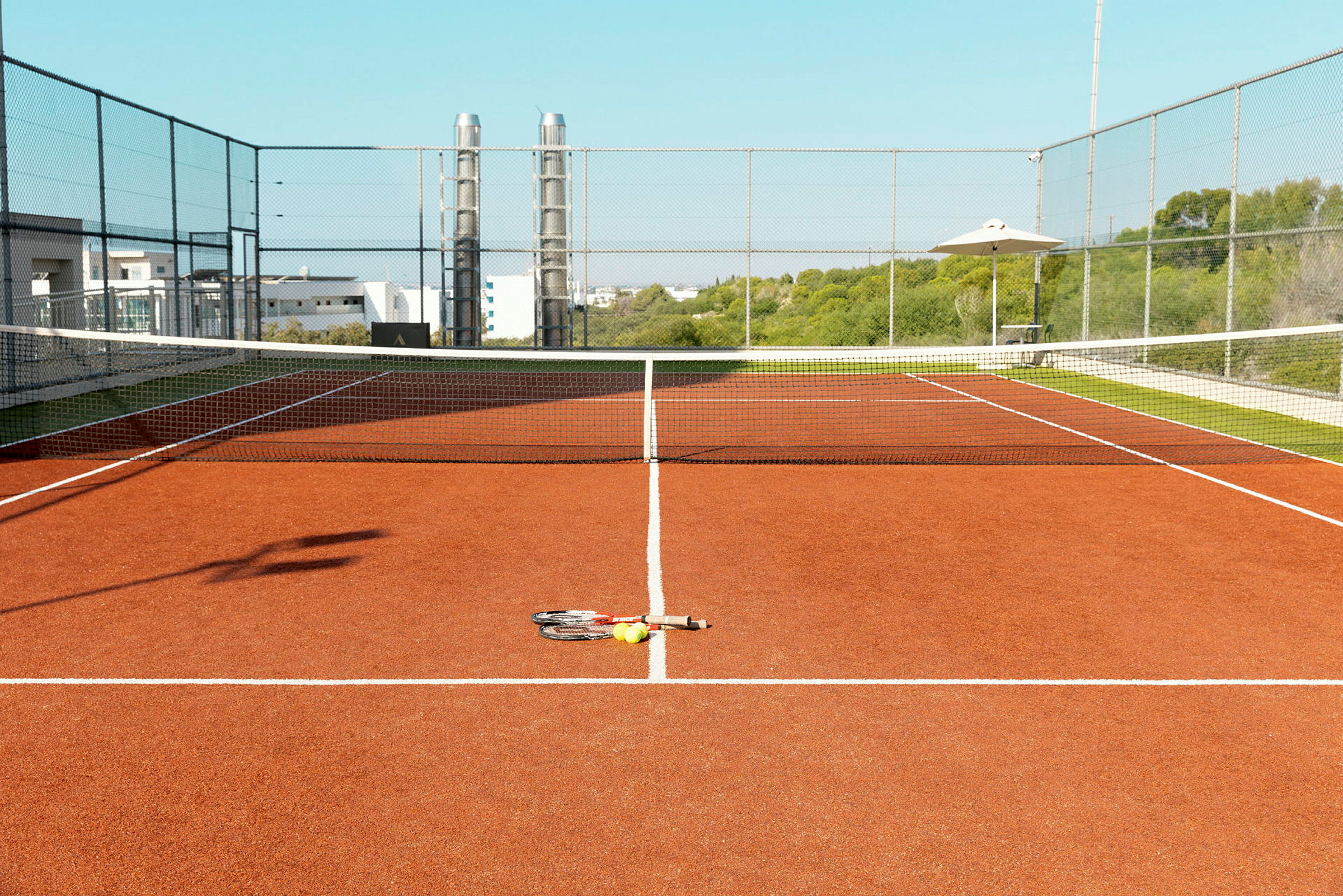 Bild av en tennisbana med racket och bollar på marken. (AI-genererad text)