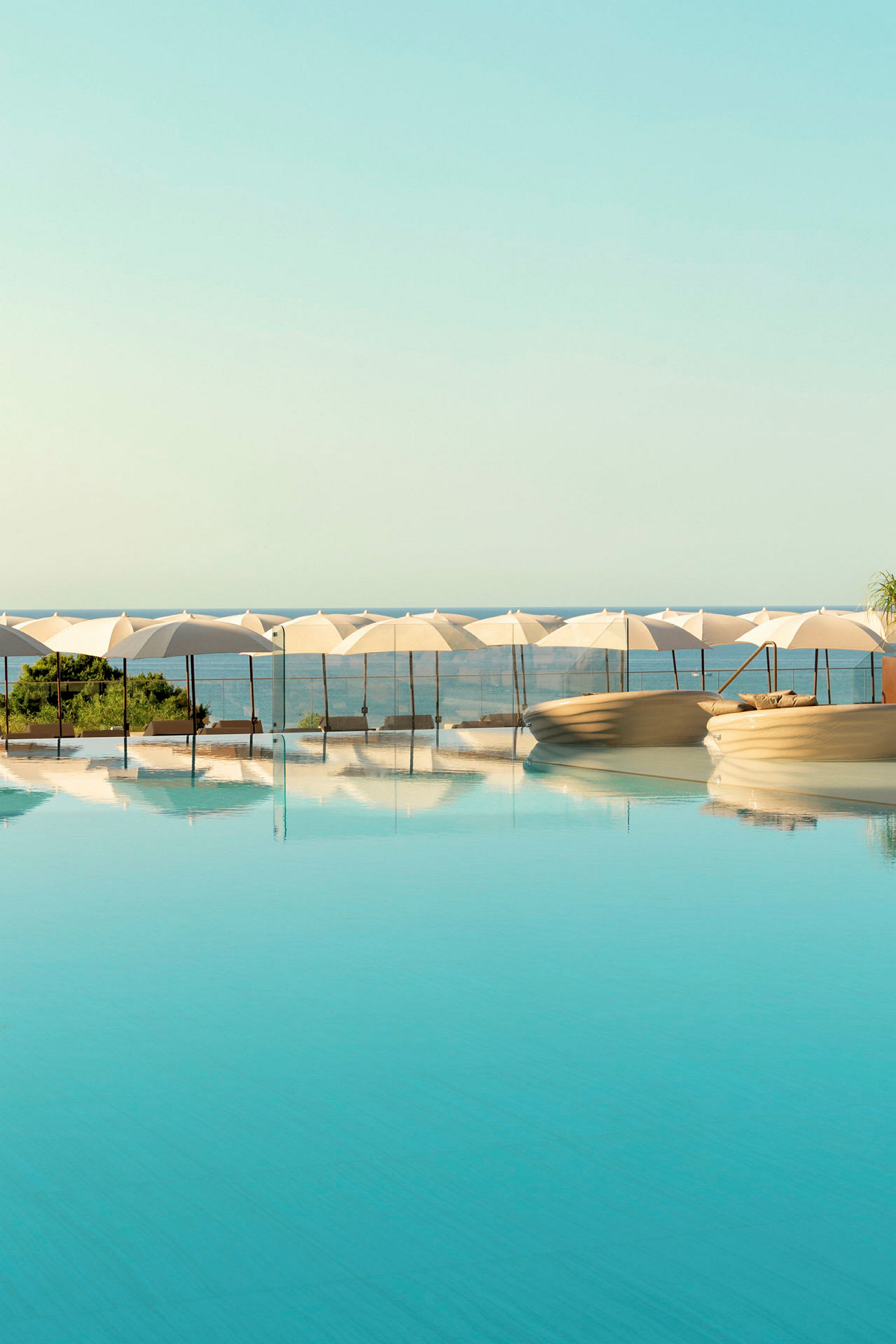 En infinitypool med parasoller och solstolar vid kanten. (AI-genererad text)