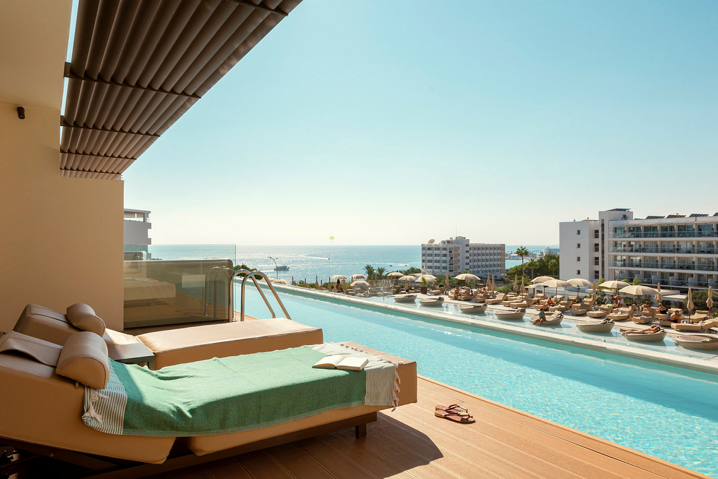 Solstolar och pool med utsikt över havet i en semesterort. (AI-genererad text)
