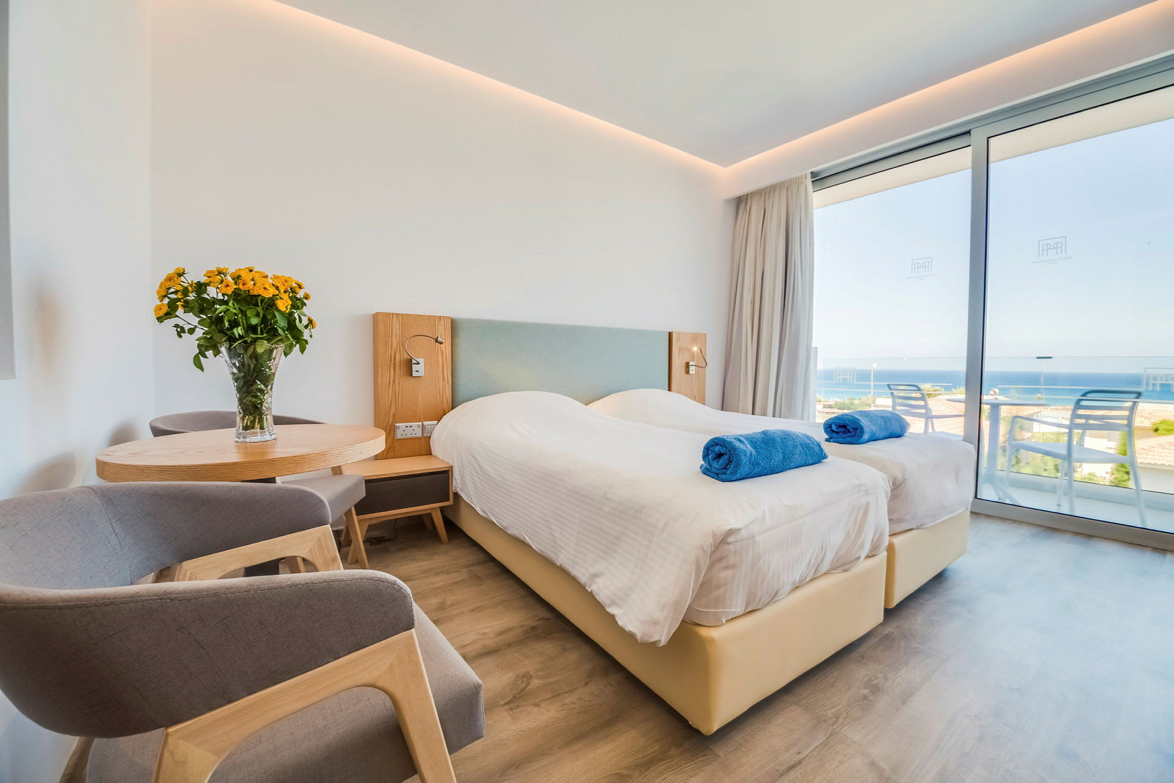 Hotellrum med två enkelsängar, utsikt över havet. (AI-genererad text)