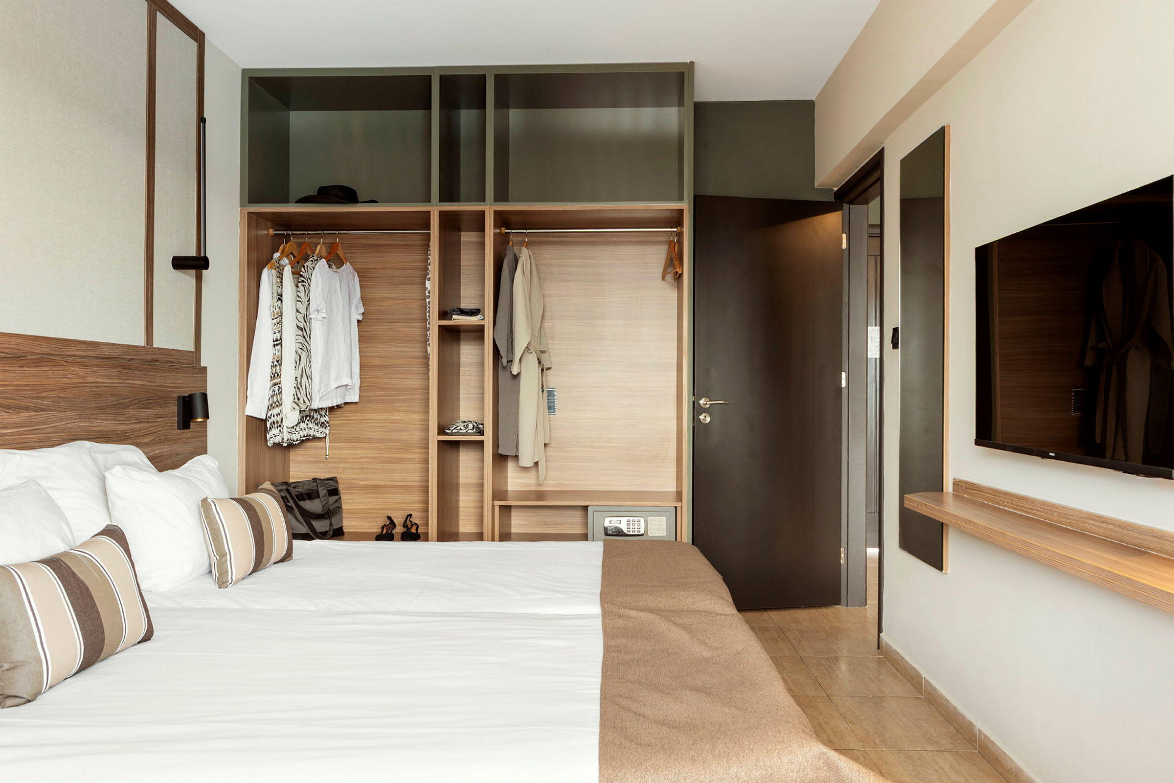 Ett hotellrum med en dubbelsäng och en öppen garderob. (AI-genererad text)