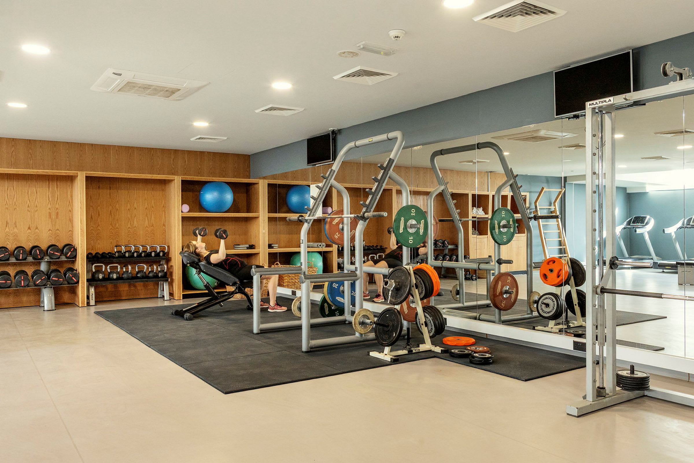 Gym med träningsutrustning och spegelvägg. (AI-genererad text)
