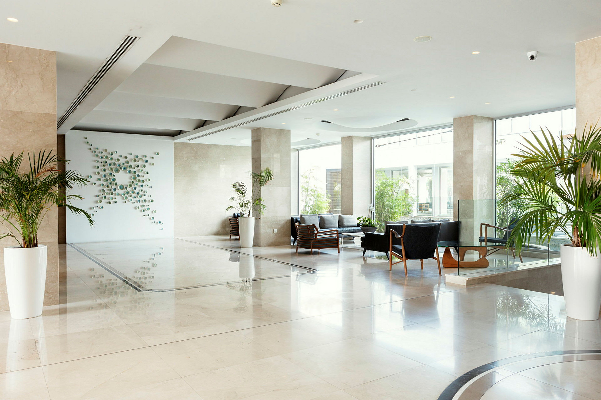 Modern hotellobby med sittgrupper och växter. (AI-genererad text)