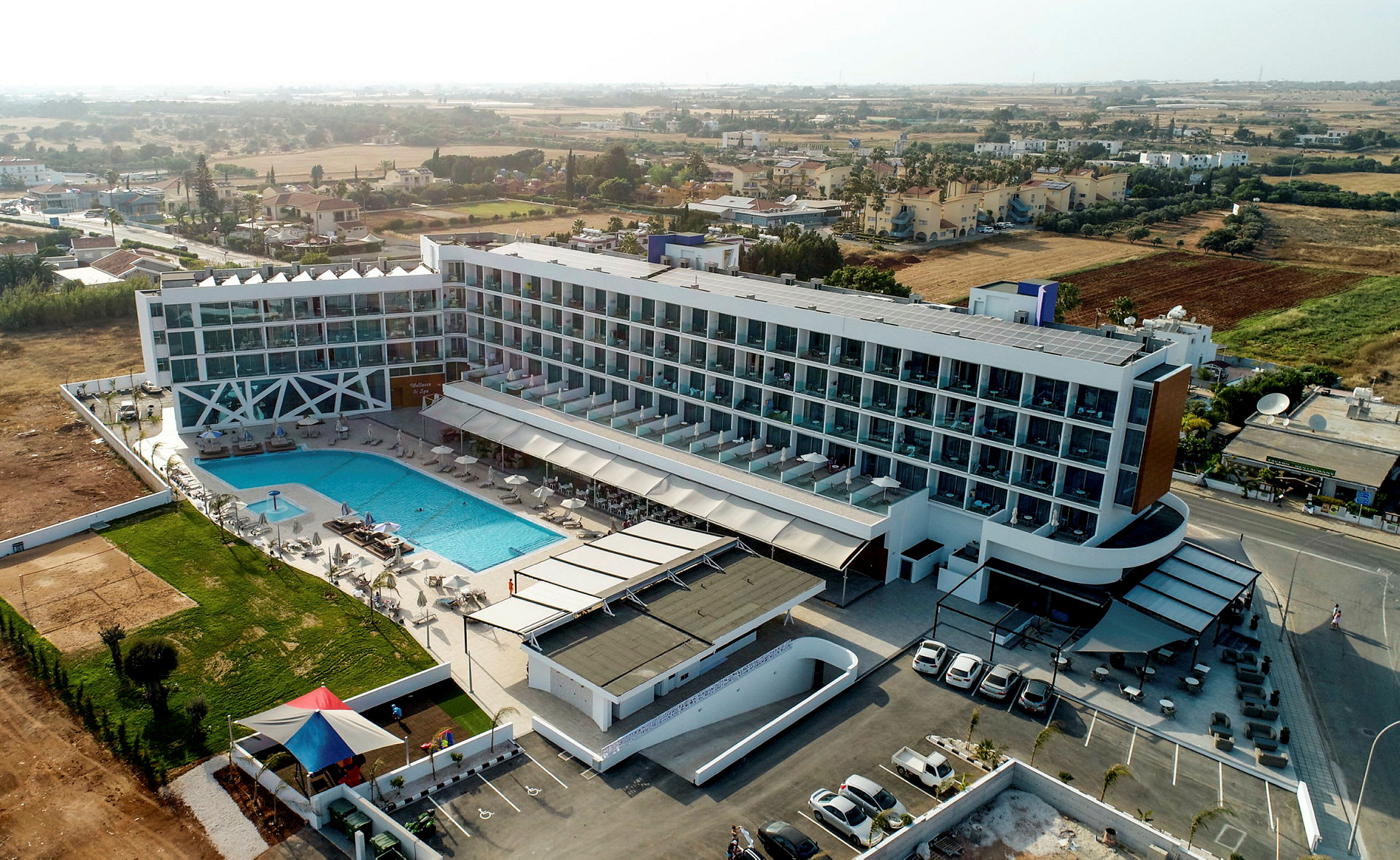 Hotellbyggnad med pool och omgivande landskap. (AI-genererad text)