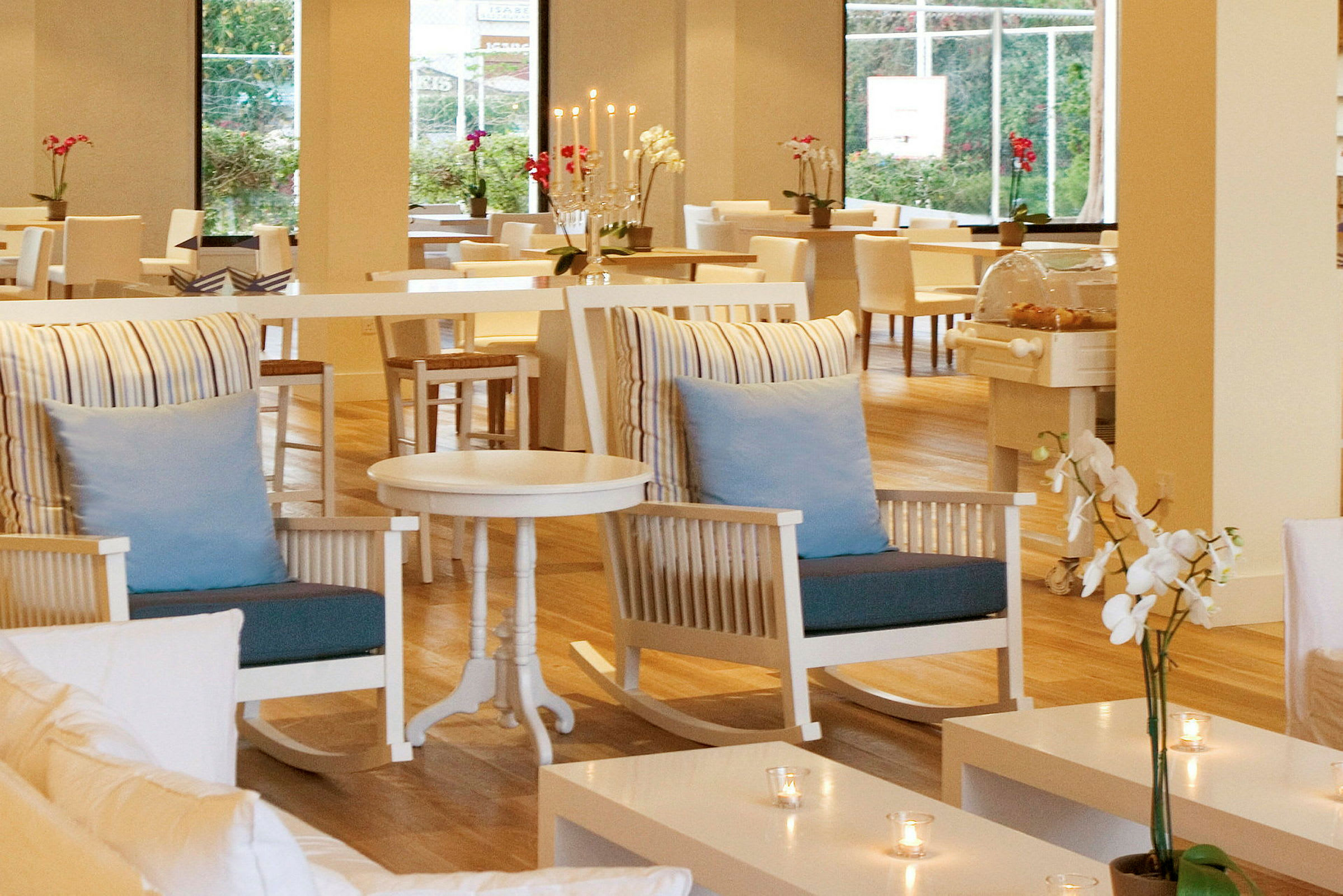 Interiör av en restaurang med ljusa möbler, blommor och dekorationer. (AI-genererad text)