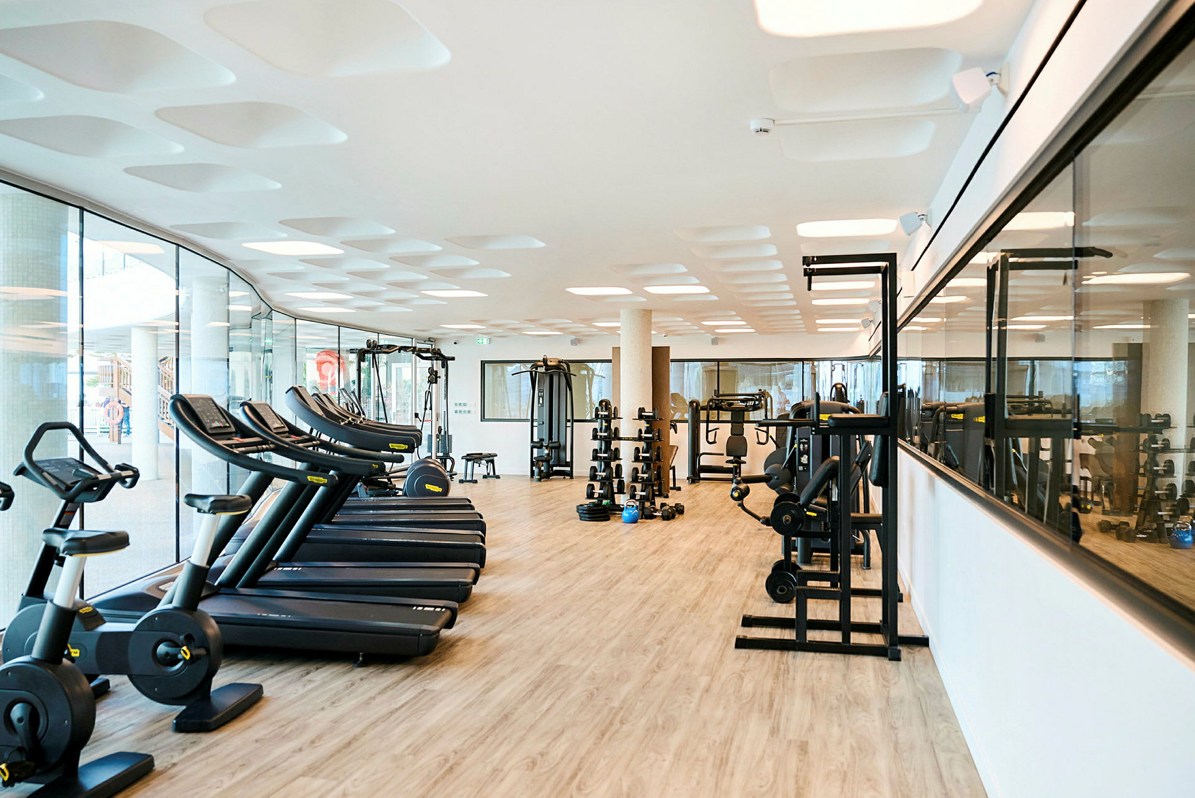 Ett modernt gym med träningsmaskiner, löpband och fria vikter. (AI-genererad text)