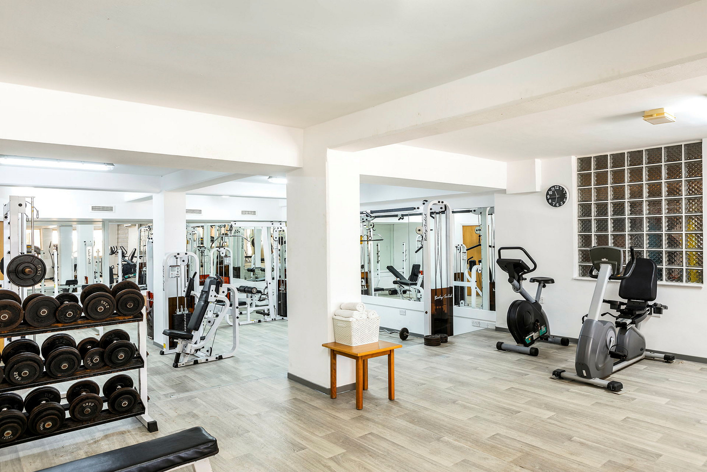 Gym med träningsmaskiner, hantlar och konditionscyklar. (AI-genererad text)