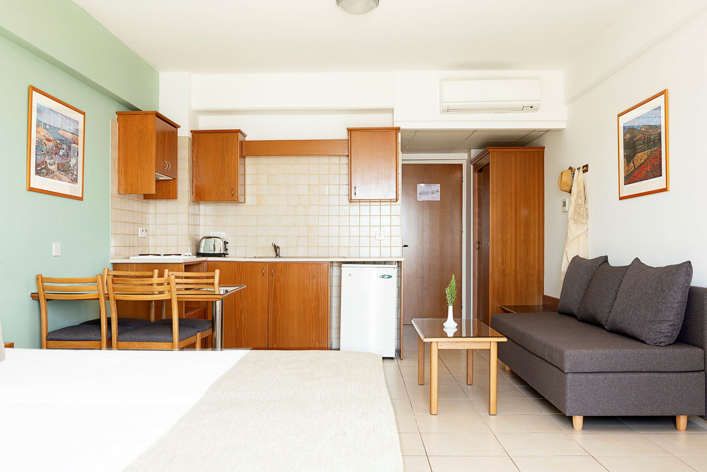 En hotellstudio med kök, matbord och sittgrupp. (AI-genererad text)