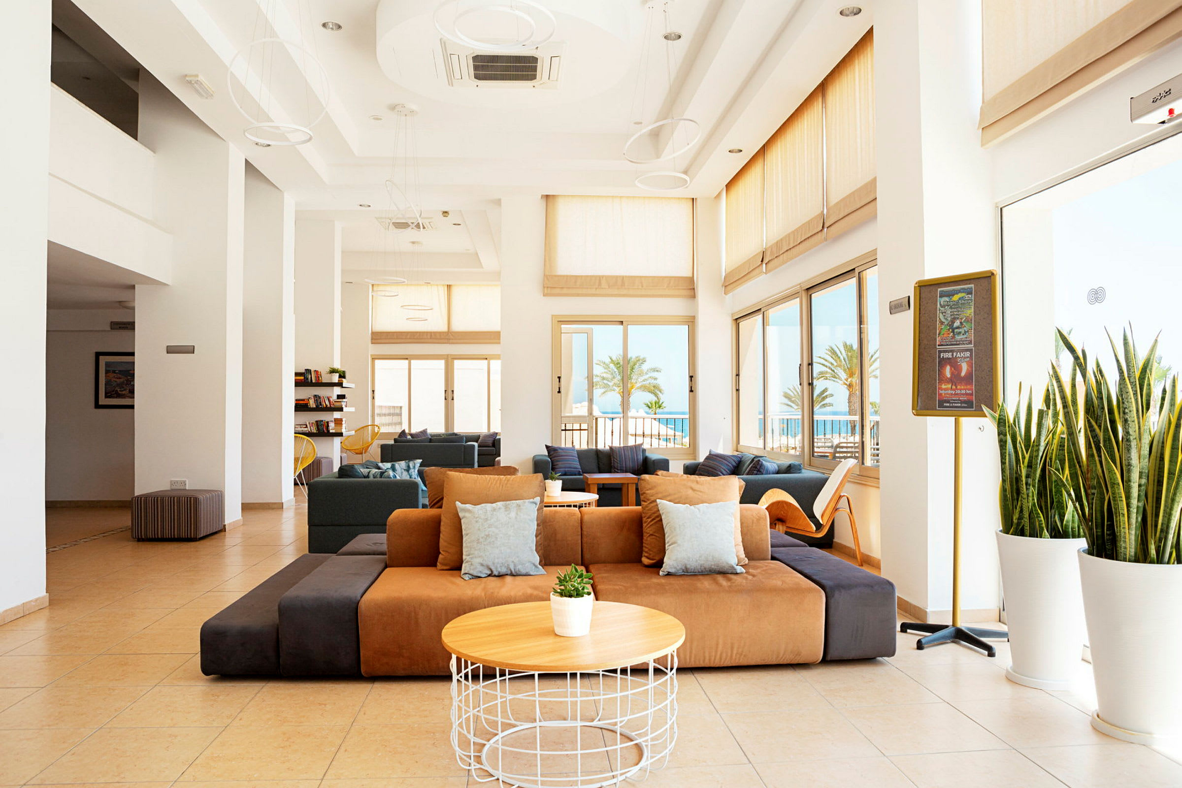 Ljus hotellobby med moderna sittmöbler och stora fönster. (AI-genererad text)