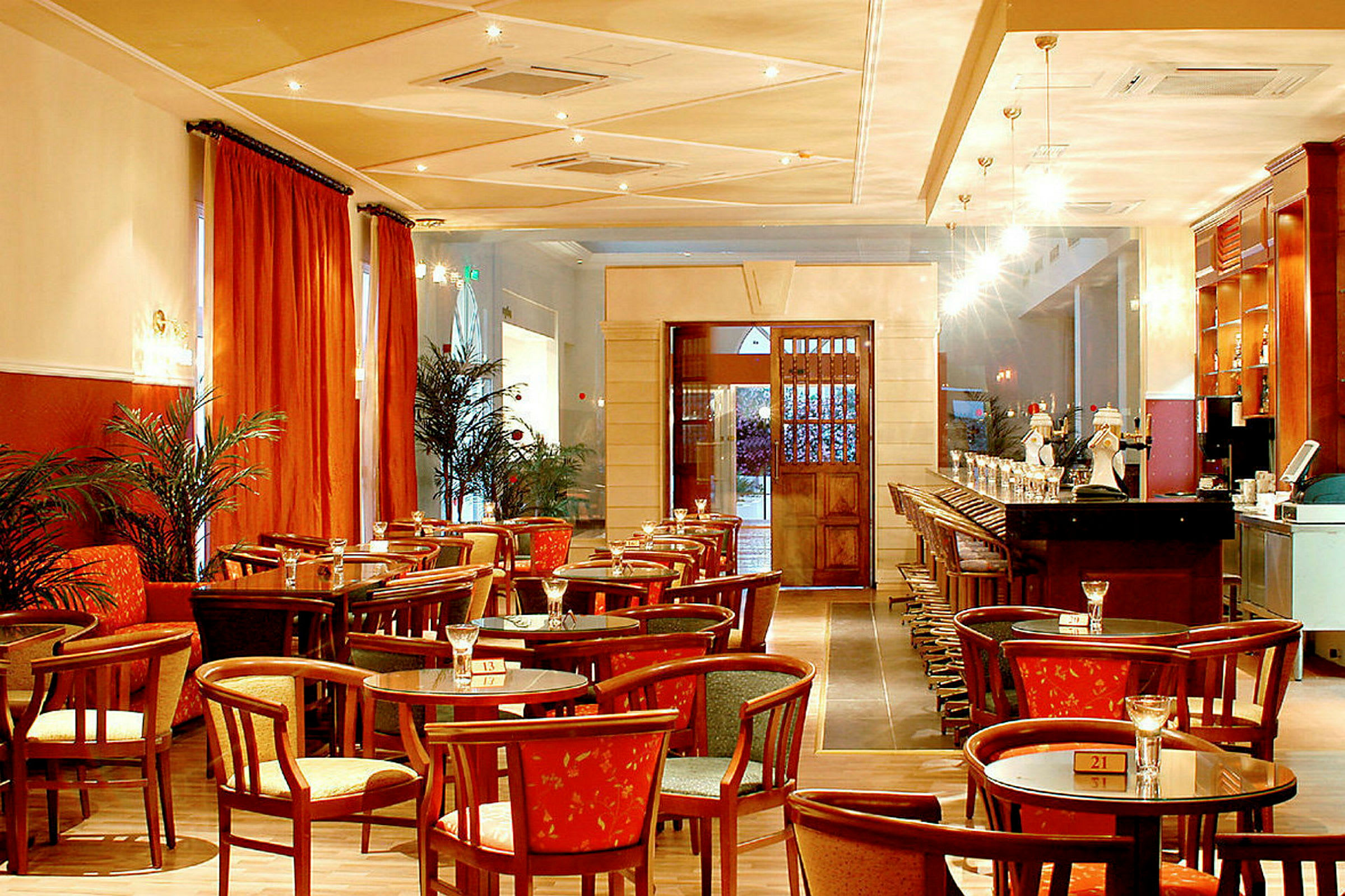 Interiör av en restaurang med bord, stolar och bar. (AI-genererad text)