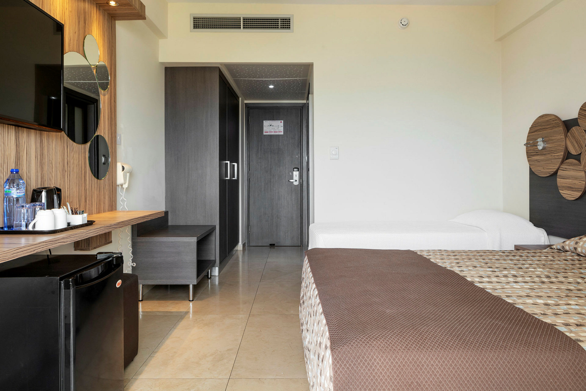 Hotellrum med två sängar, skrivbord och TV. (AI-genererad text)