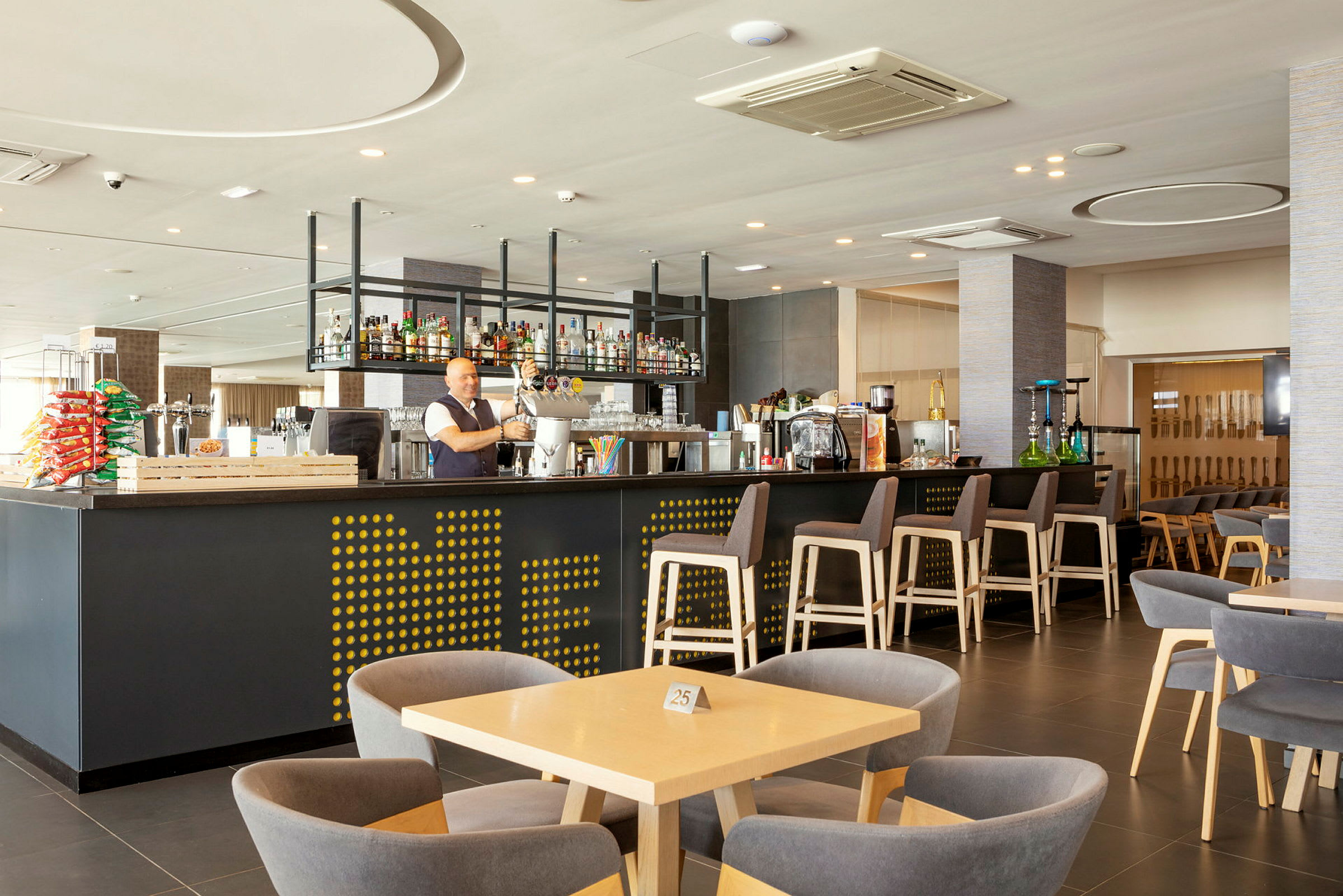 Interiör av en modern bar med sittplatser och belysning. (AI-genererad text)