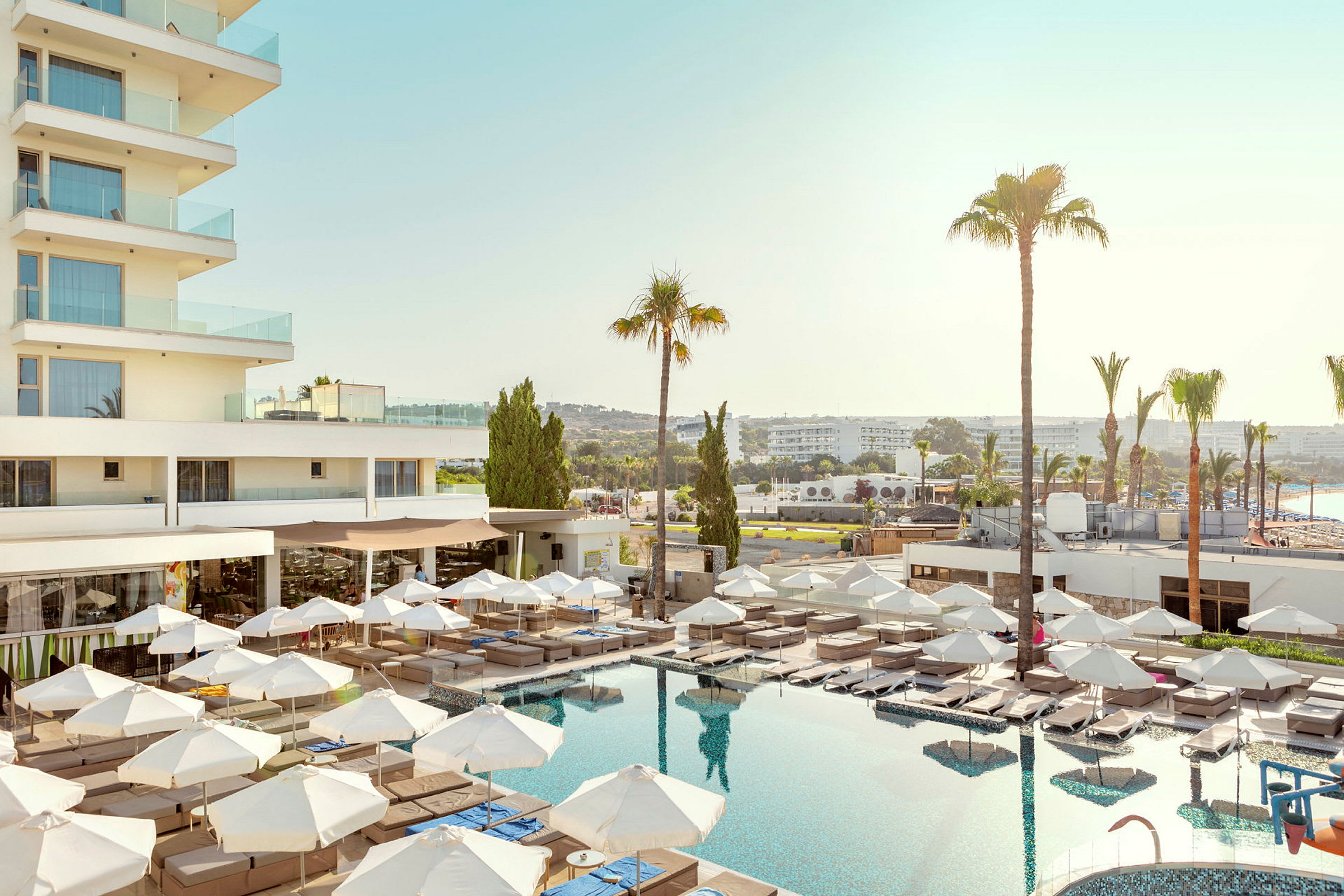 Hotellutsikt med pool, solstolar och parasoll. (AI-genererad text)