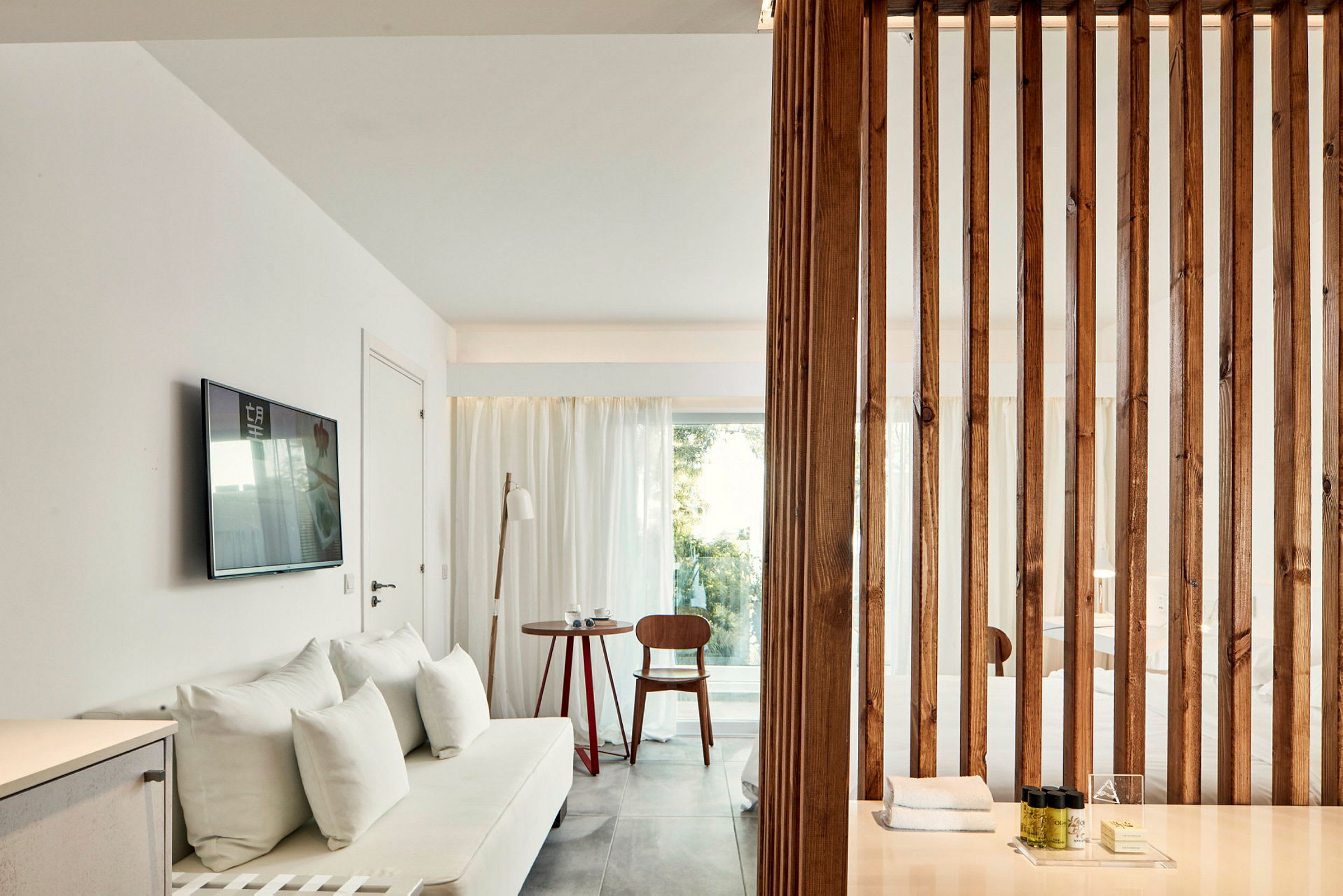 Bild av ett modernt hotellrum med ljus inredning, trädetaljer och en soffa. (AI-genererad text)