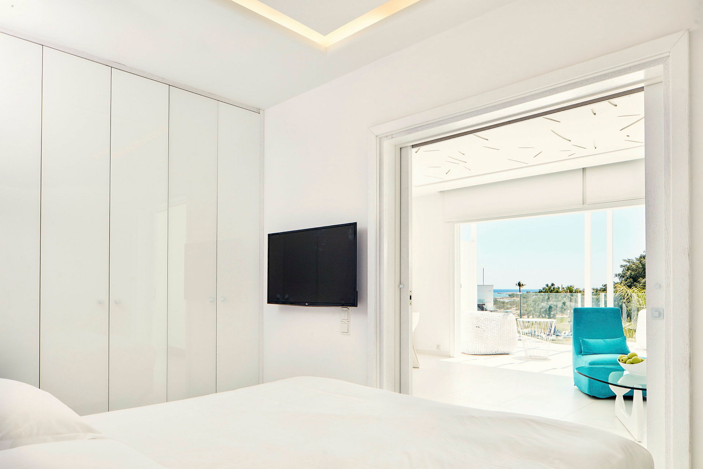 Modernt hotellrum med platt-TV och anslutande balkong med utsikt. (AI-genererad text)
