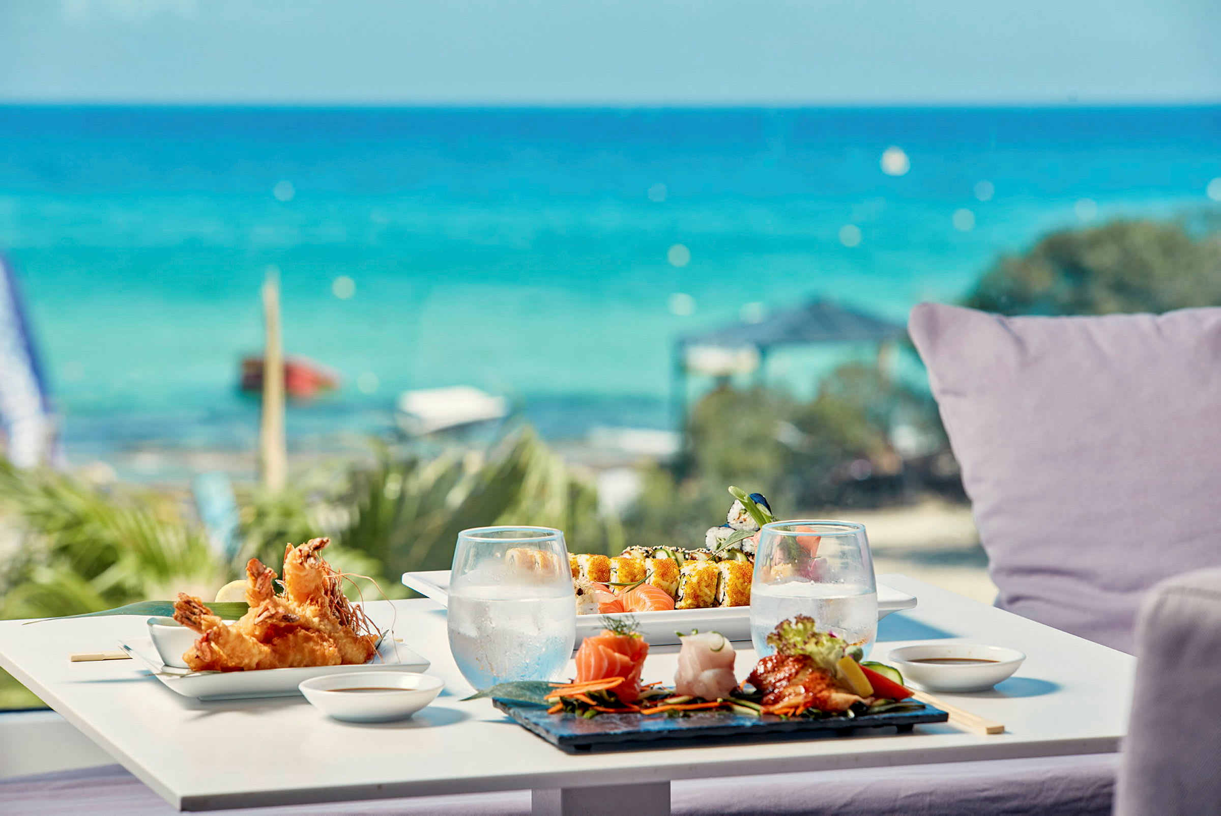 Ett bord vid havet med sushi och annat i asiatisk stil. (AI-genererad text)