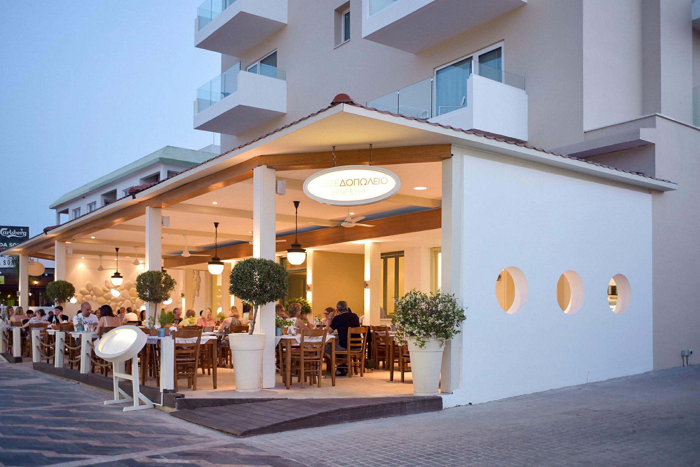 Utomhusterrass med sittplatser på en restaurang intill en byggnad. (AI-genererad text)