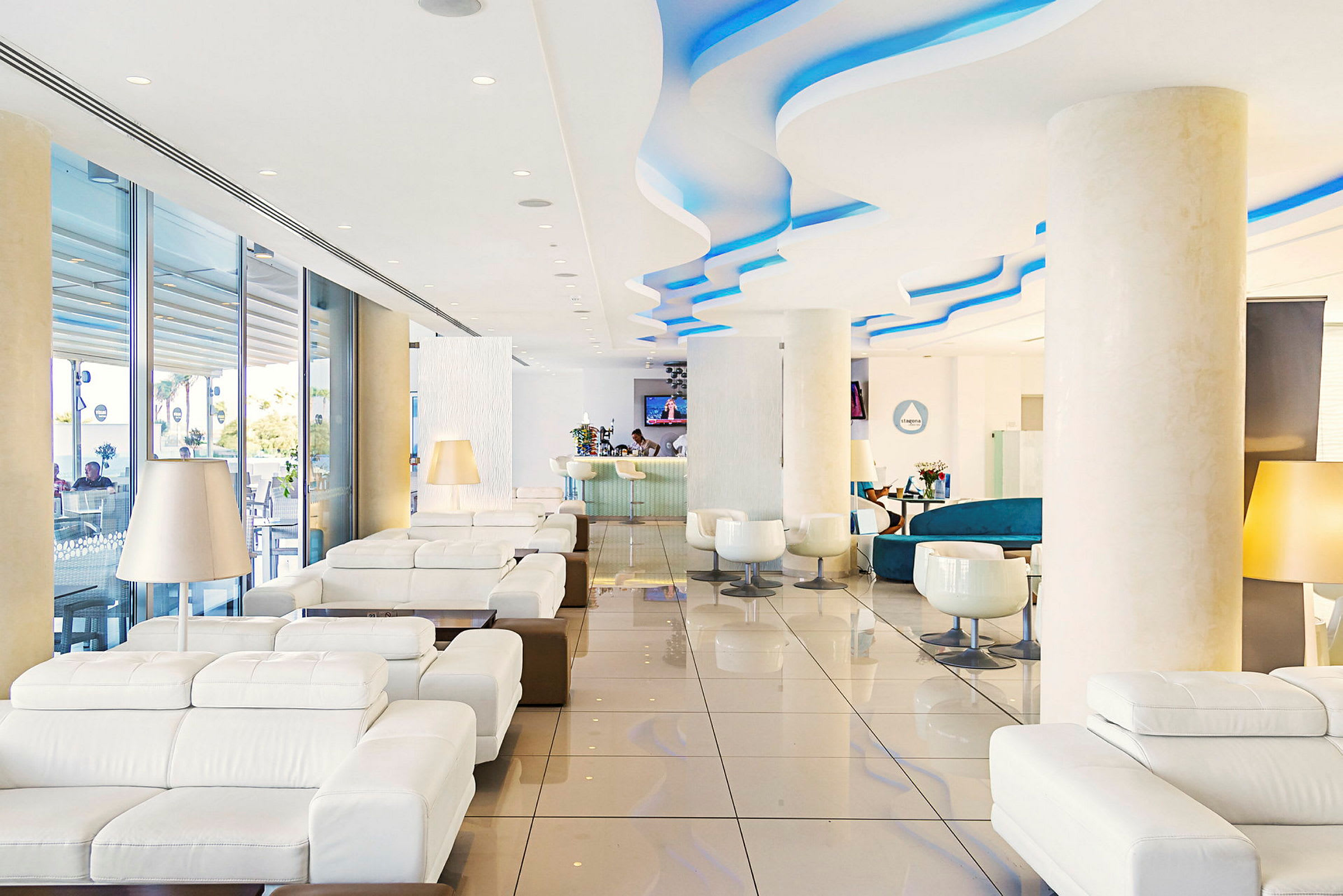 Hotelllobby med vita soffor och, i bakgrunden, en reception. (AI-genererad text)