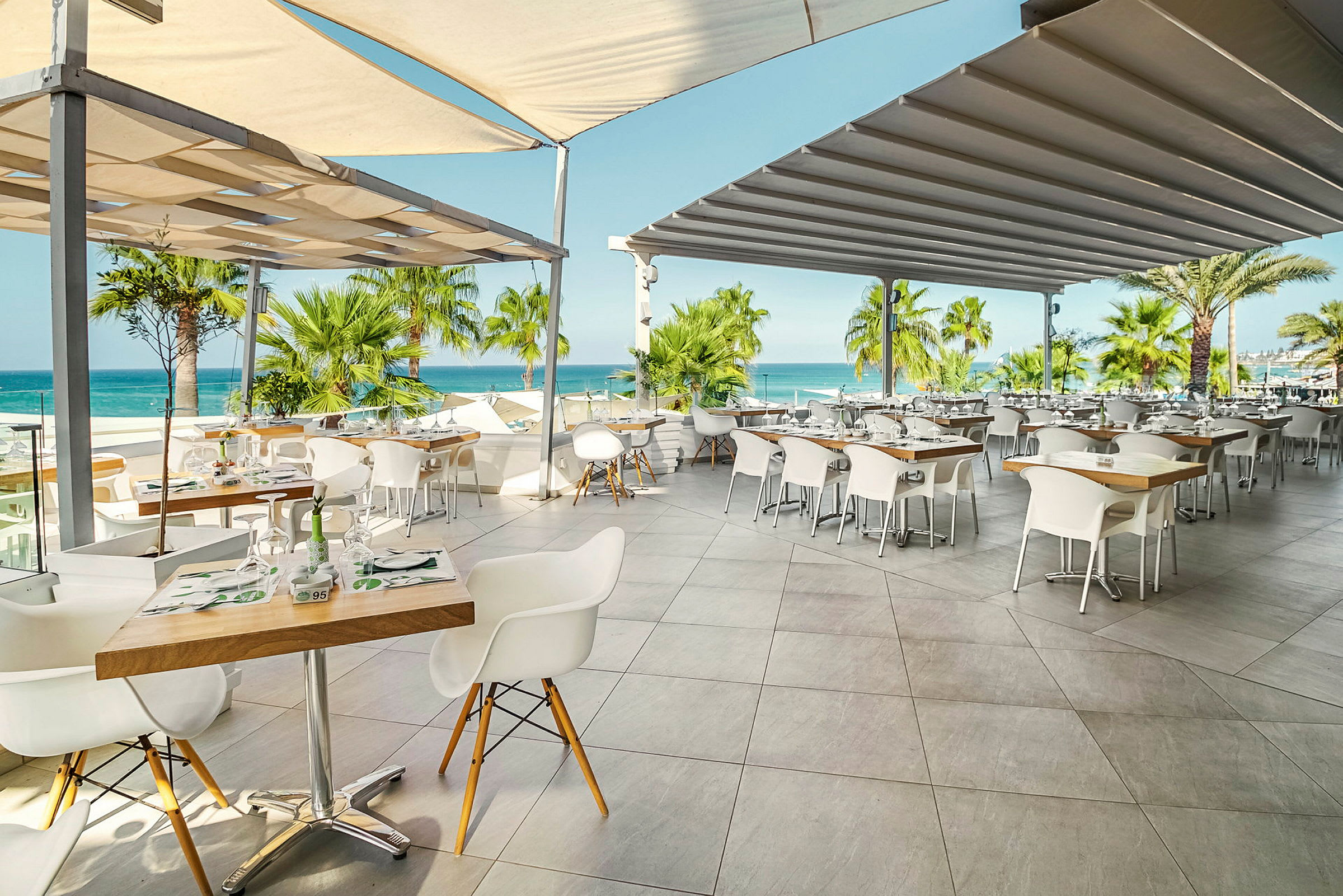 Restaurang med uteservering, utsikt mot havet. (AI-genererad text)