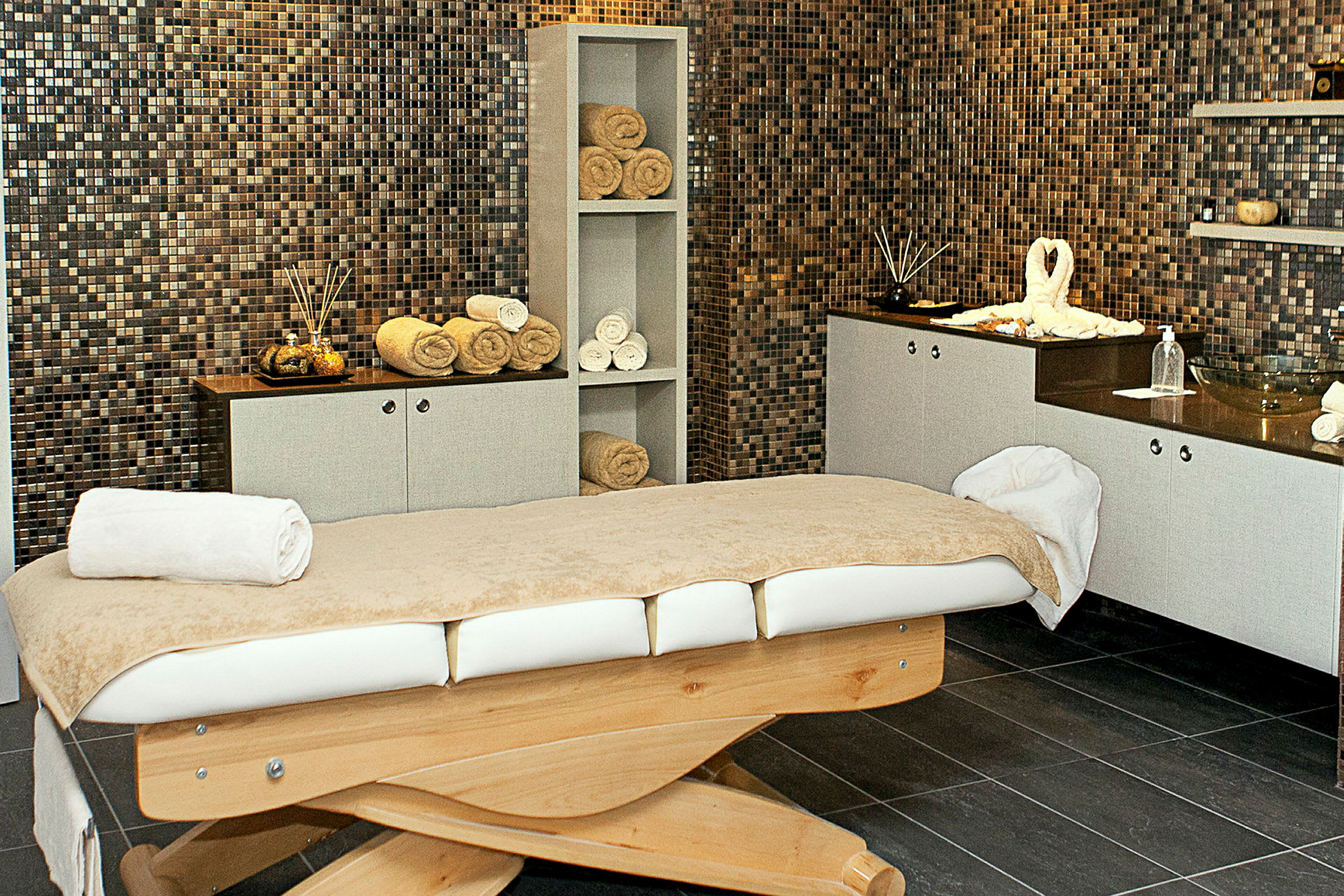 Ett massagerum med en behandlingsbänk och rullade handdukar. (AI-genererad text)