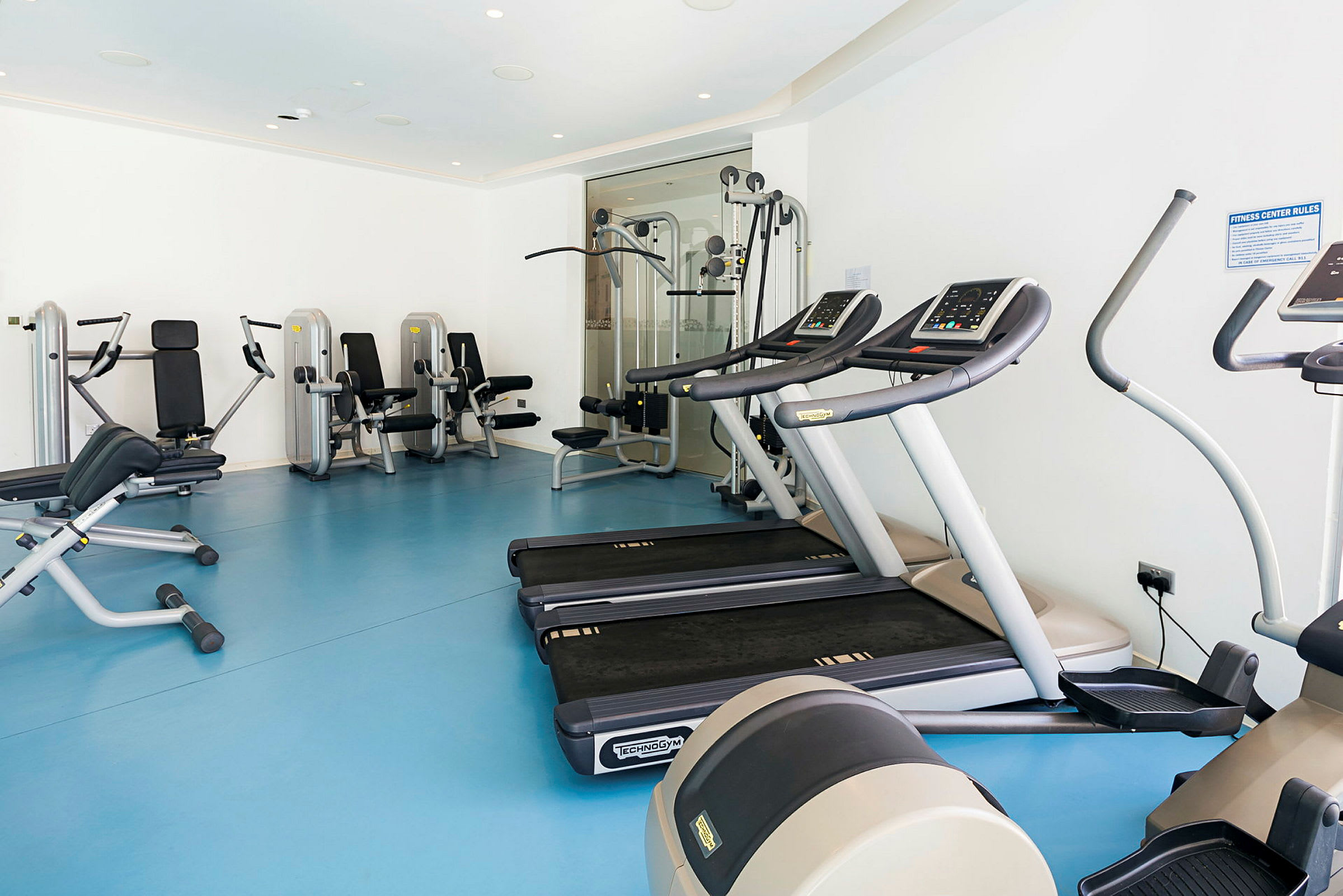 Gym med träningsutrustning som löpband och styrkemaskiner. (AI-genererad text)