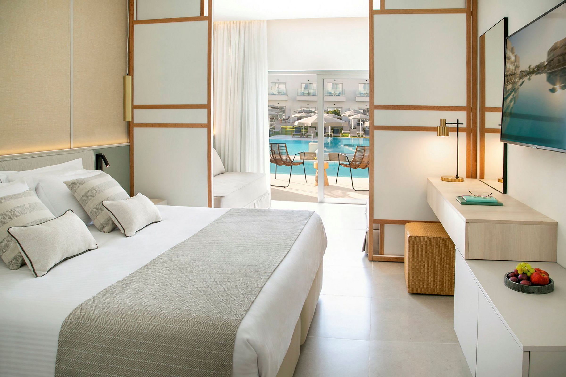 Modernt hotellrum med utsikt mot en solterrass och hotellpool. (AI-genererad text)