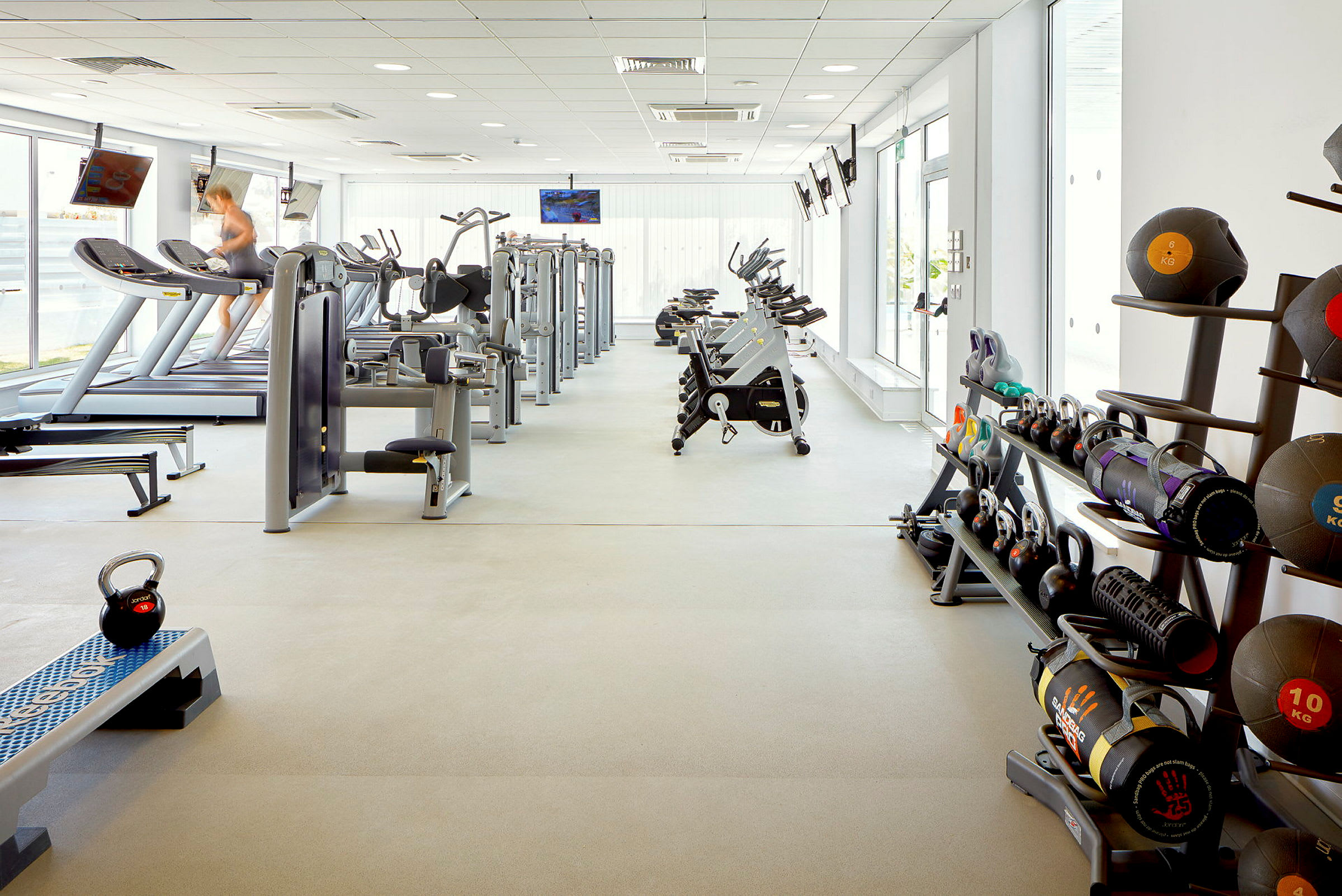 Ett gym med olika träningsmaskiner, vikter och annat träningsutrustning. (AI-genererad text)