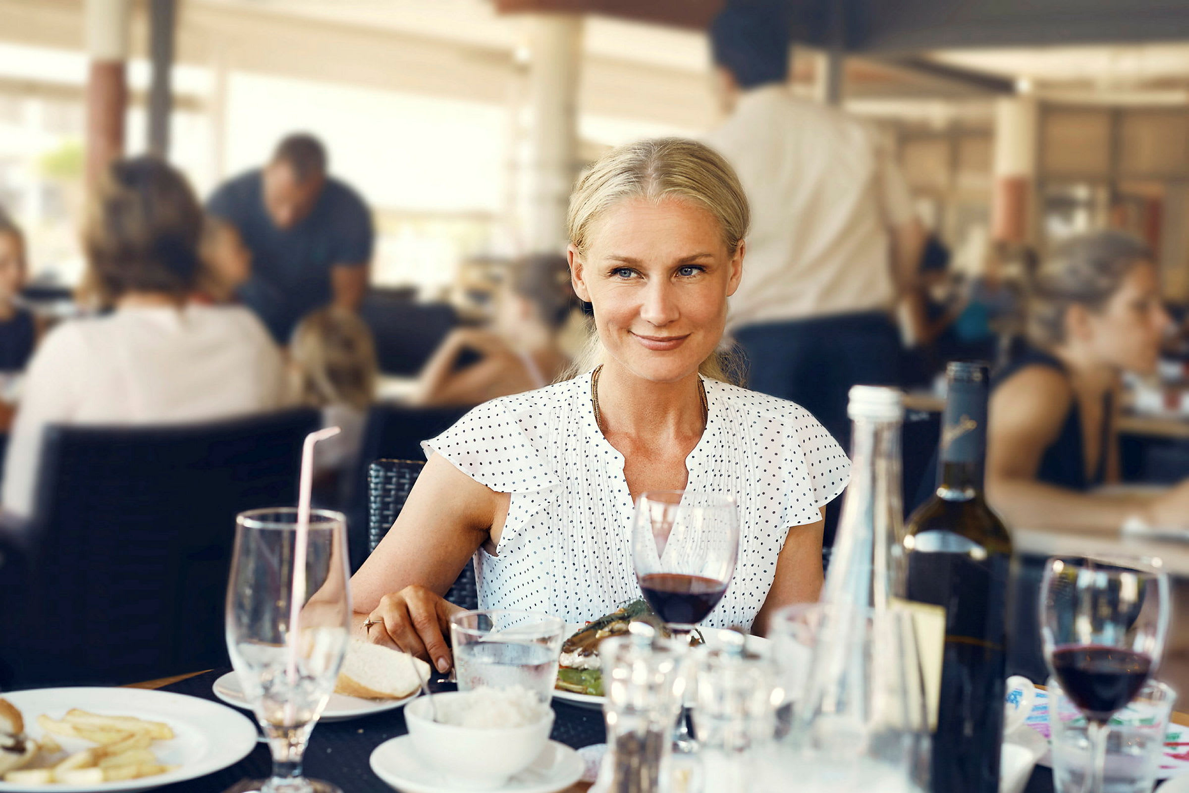 En person sitter vid ett bord på en restaurang med olika drycker och mat serverade. (AI-genererad text)
