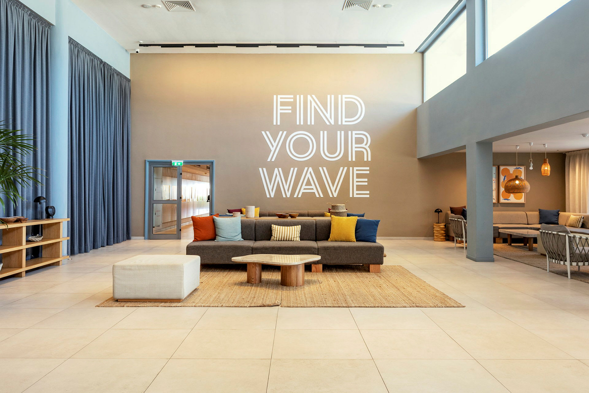 Ett modernt rum med sittplatser och en text på väggen som säger 'Find Your Wave'. (AI-genererad text)