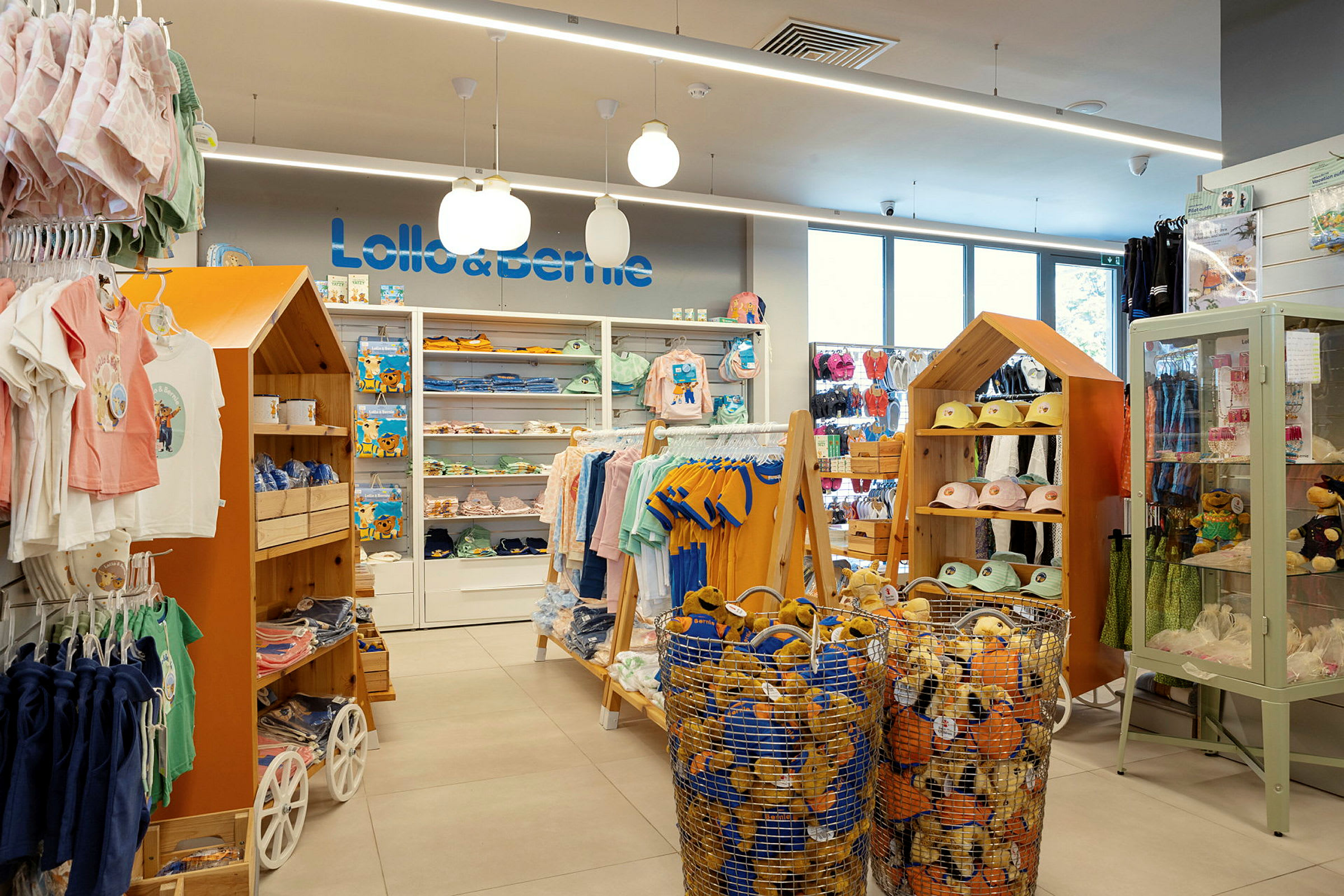 En butik interiör med barnkläder och leksaker. Hyllor, korgar och displayskåp visar produkter. (AI-genererad text)