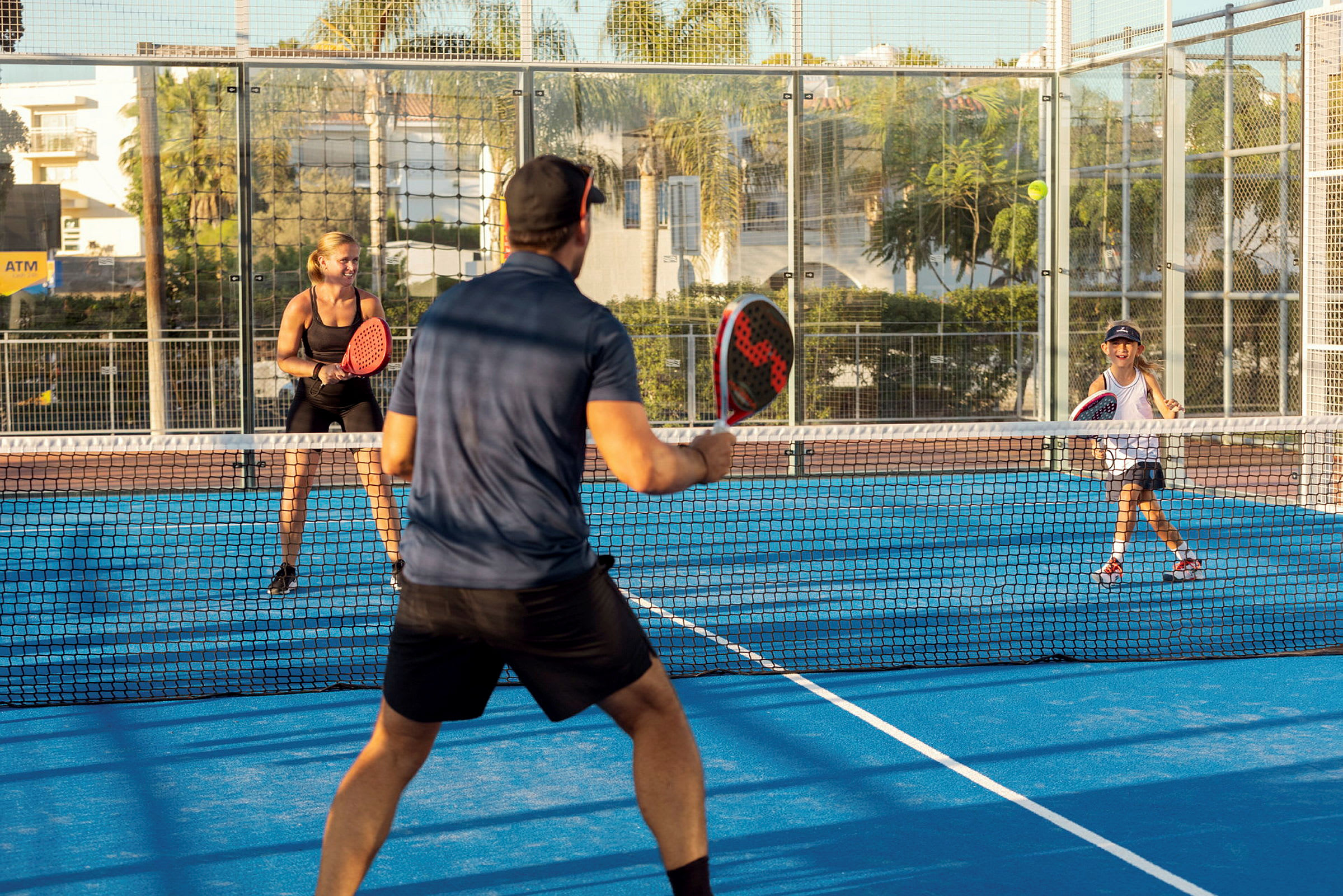 Fyra personer spelar padeltennis på en utomhusbana. (AI-genererad text)