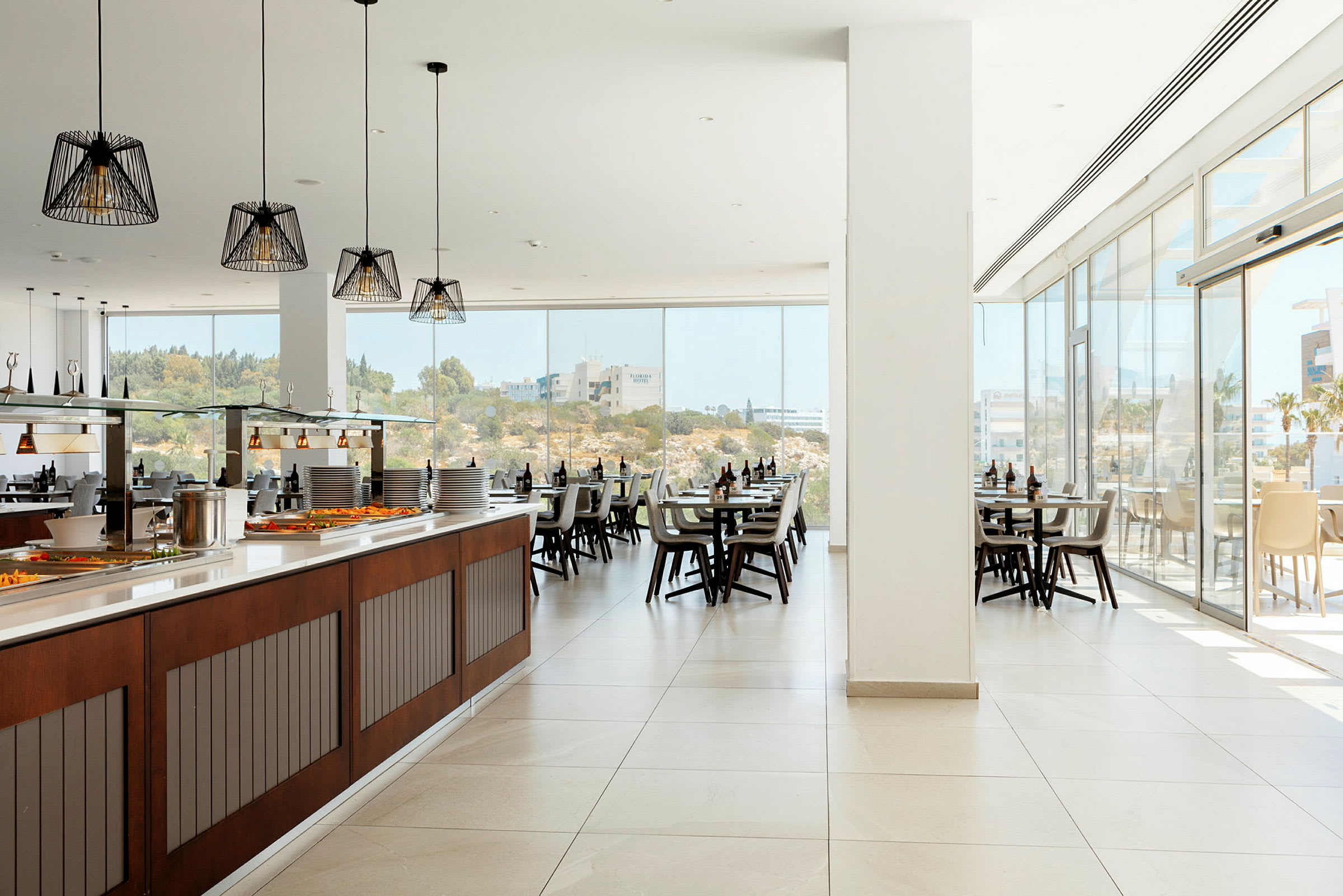 En rymlig restaurang med stora fönster och en buffédisk. (AI-genererad text)