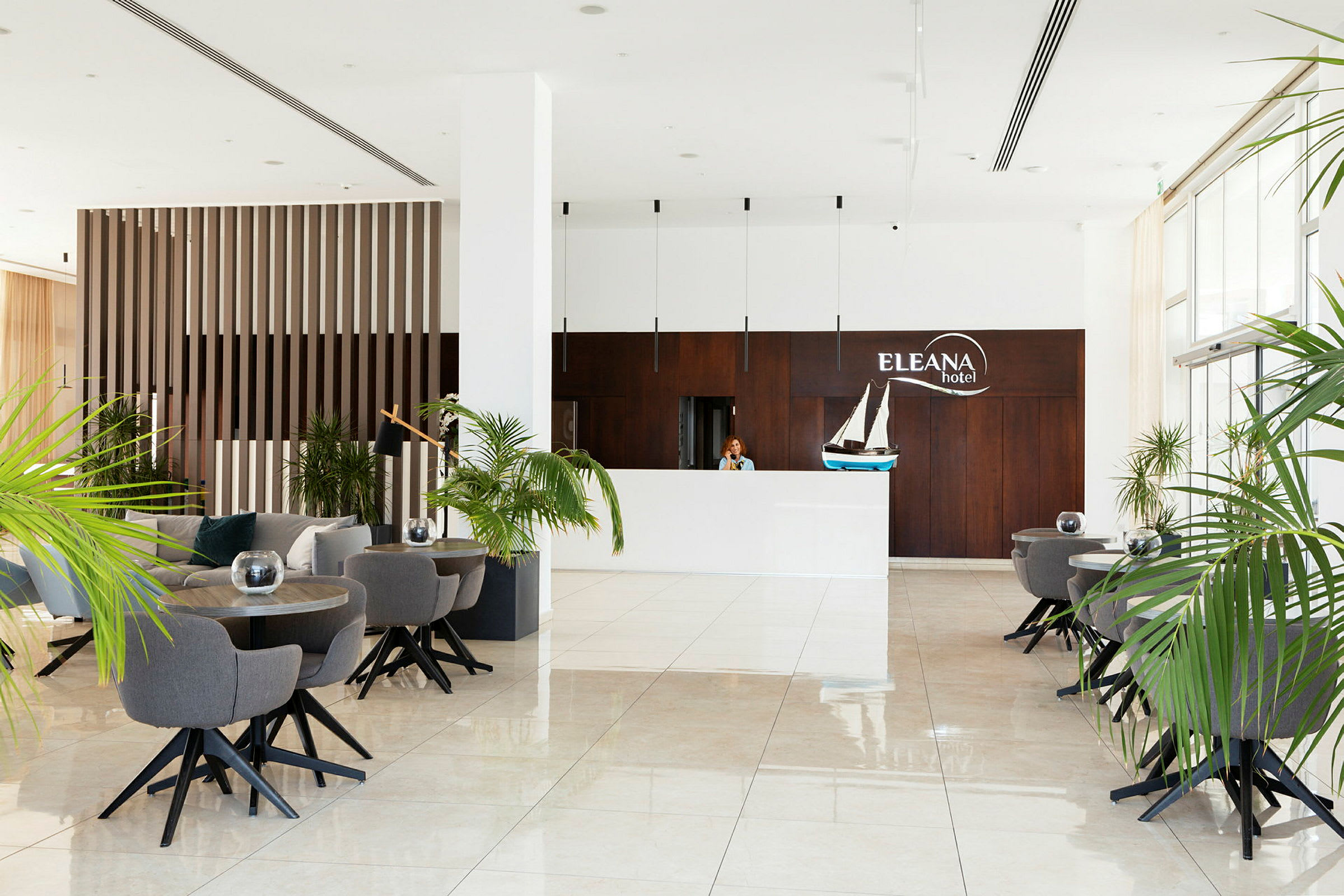 Hotellreception med vita väggar, mörkt träpanel och dekorationer. (AI-genererad text)