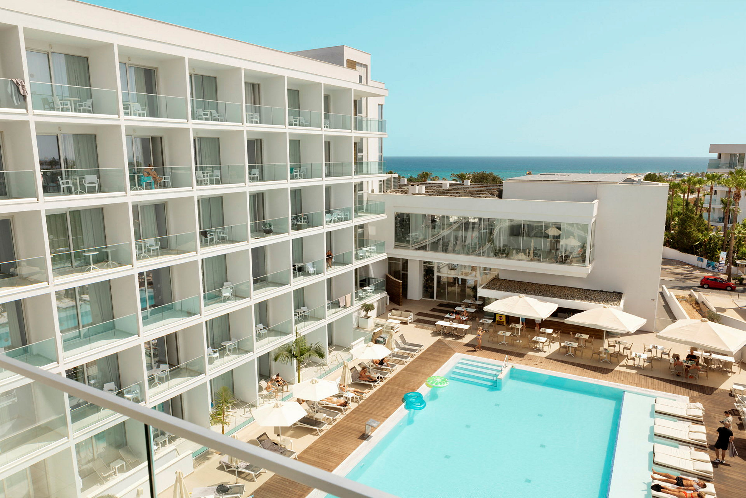 Hotell med poolområde och utsikt mot havet. (AI-genererad text)