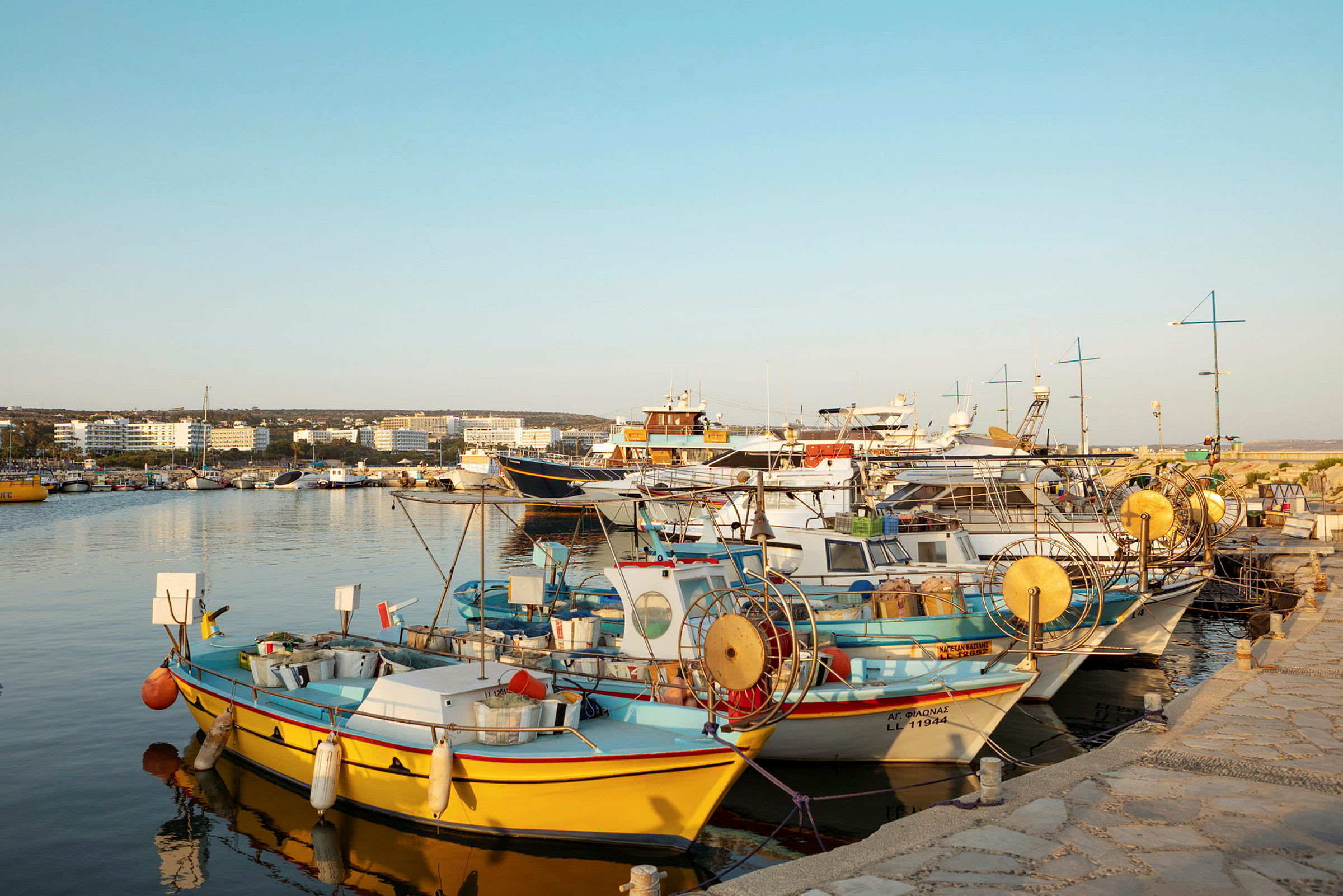 Fiskebåtar ligger förtöjda vid en kaj i en hamn. (AI-genererad text)