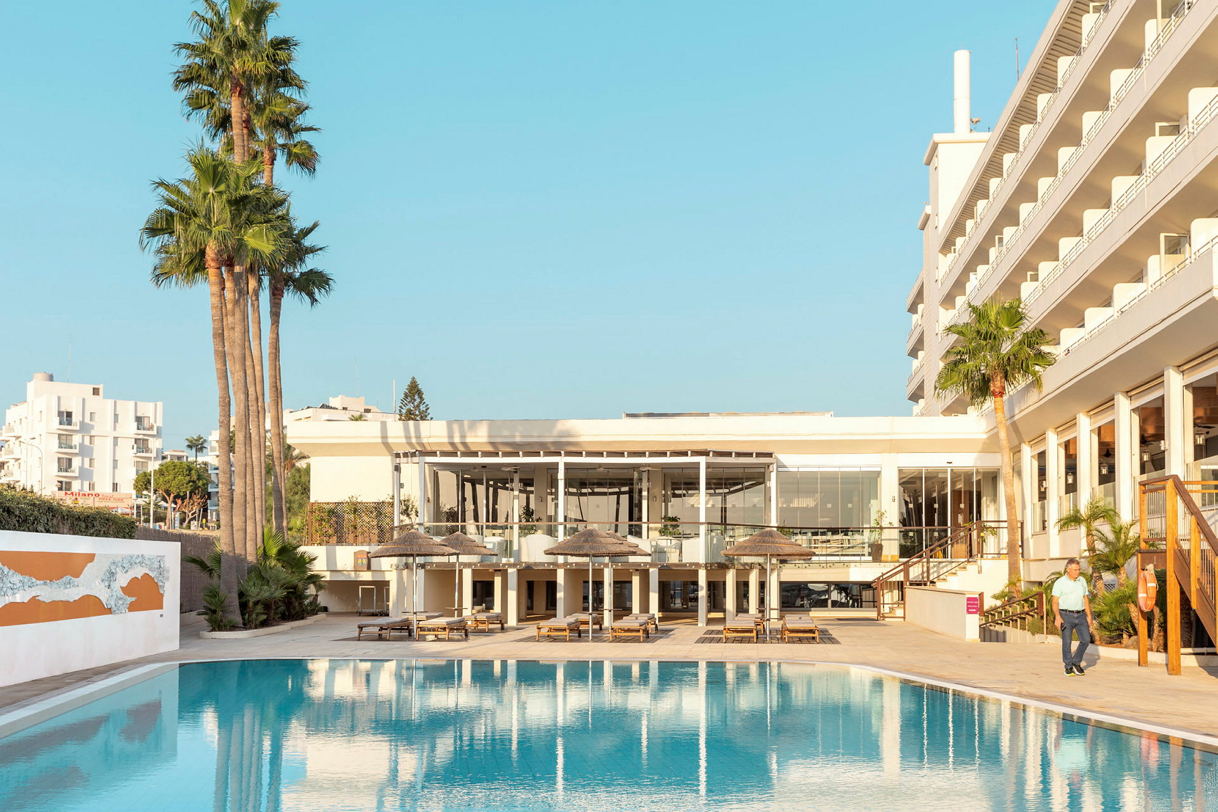 Poolområde vid hotell med solstolar och parasoller. (AI-genererad text)