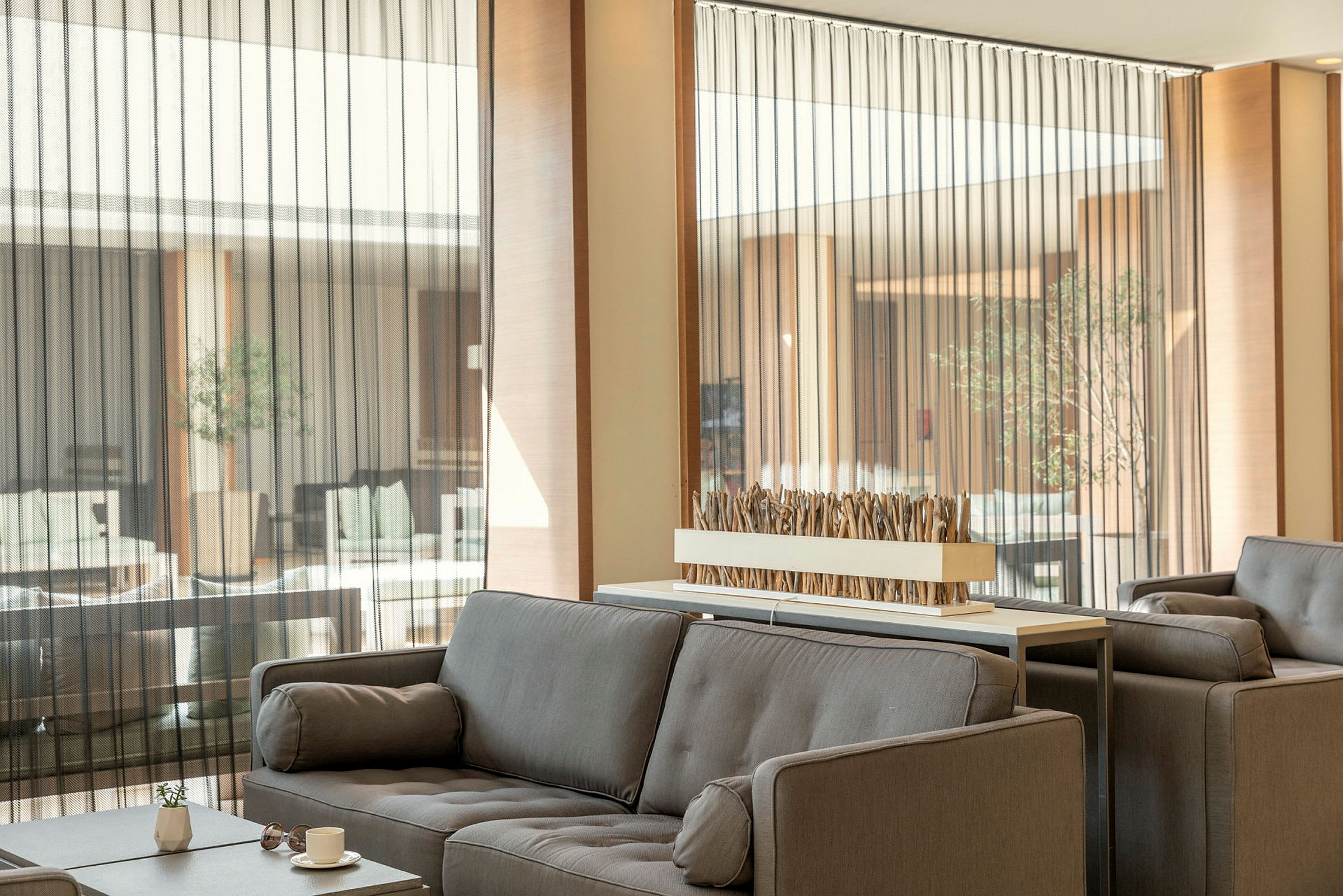 Modern lounge med grå soffor och dekorativ bordsinstallation. (AI-genererad text)