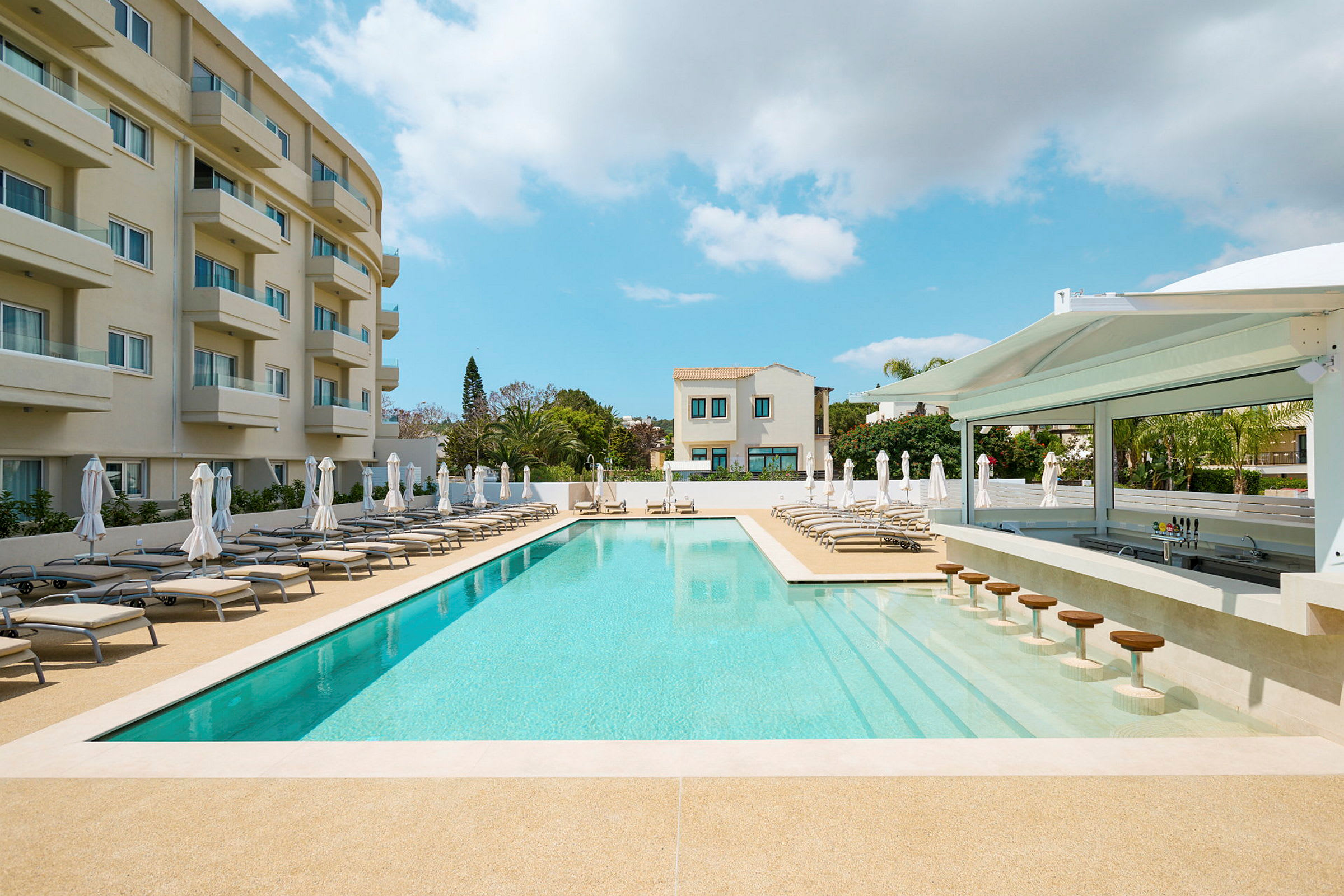 Utomhuspool med solstolar och parasoller vid ett hotell. (AI-genererad text)