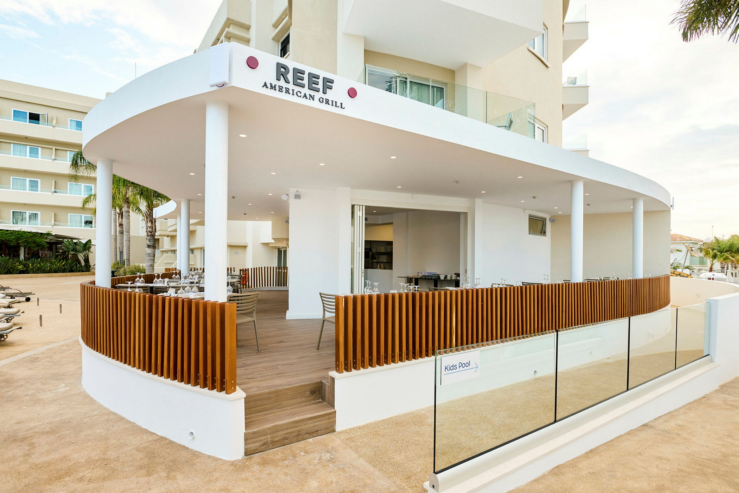 Bild av en restaurang, Reef American Grill, med en öppen terrass och modern design. (AI-genererad text)