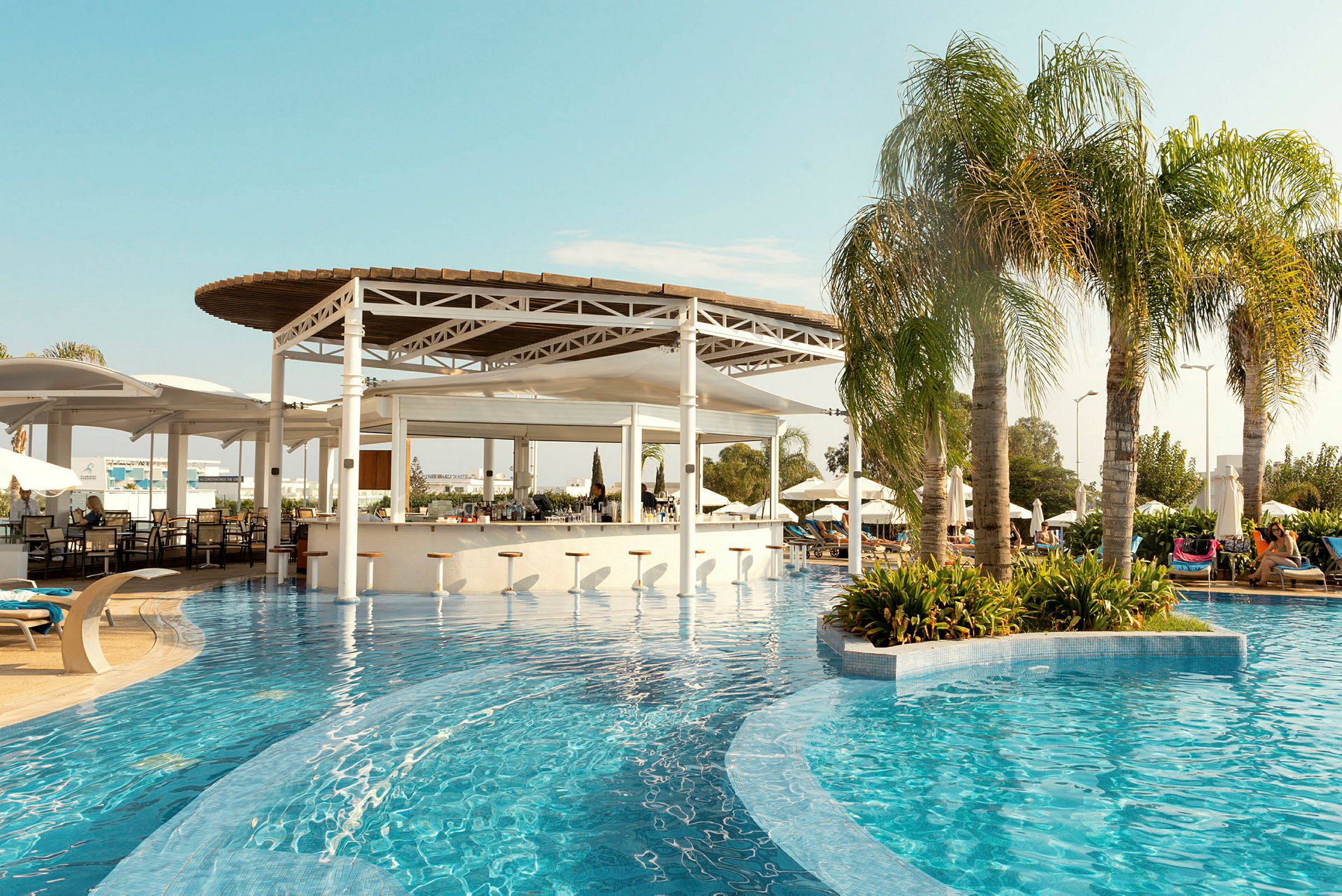 En swimmingpool med en poolbar och parasoller i bakgrunden. (AI-genererad text)