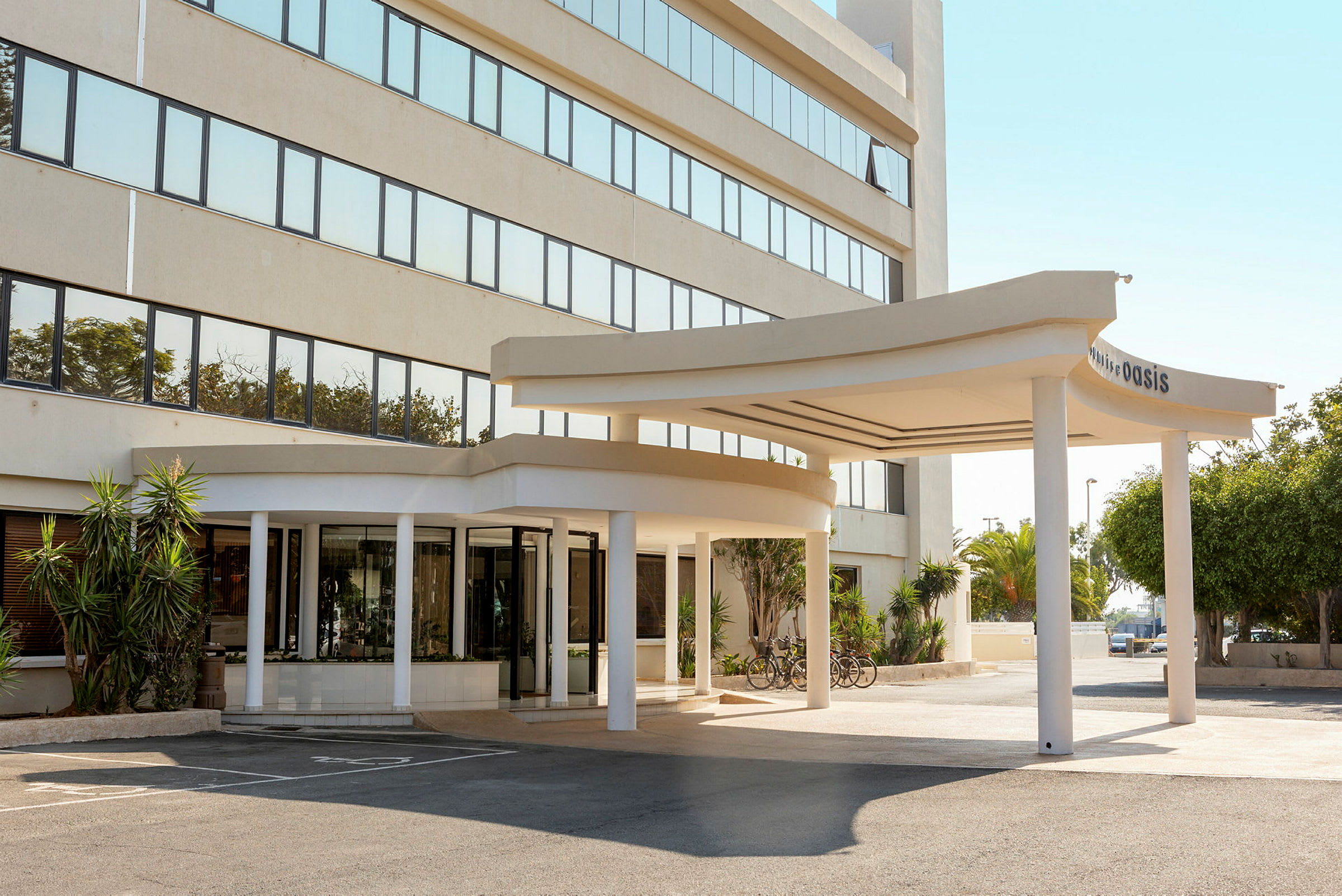 Hotellentré med en överbyggd bilväg framför och cyklar parkerade vid sidan. (AI-genererad text)