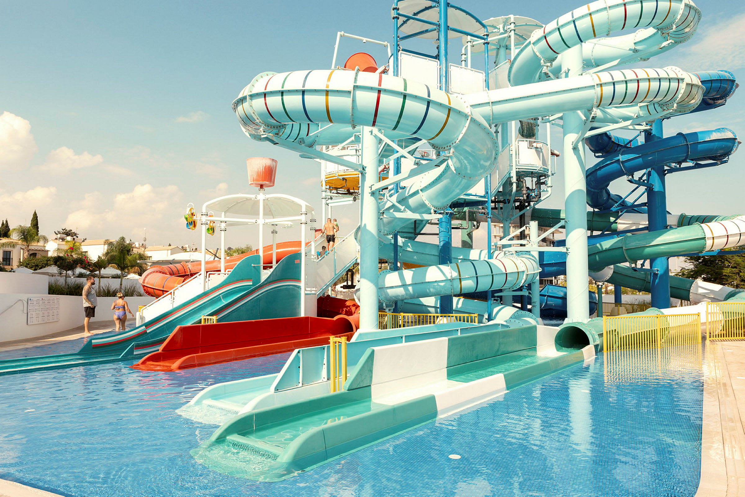 Bild på ett vattenland med flera vattenrutschbanor och pool. (AI-genererad text)